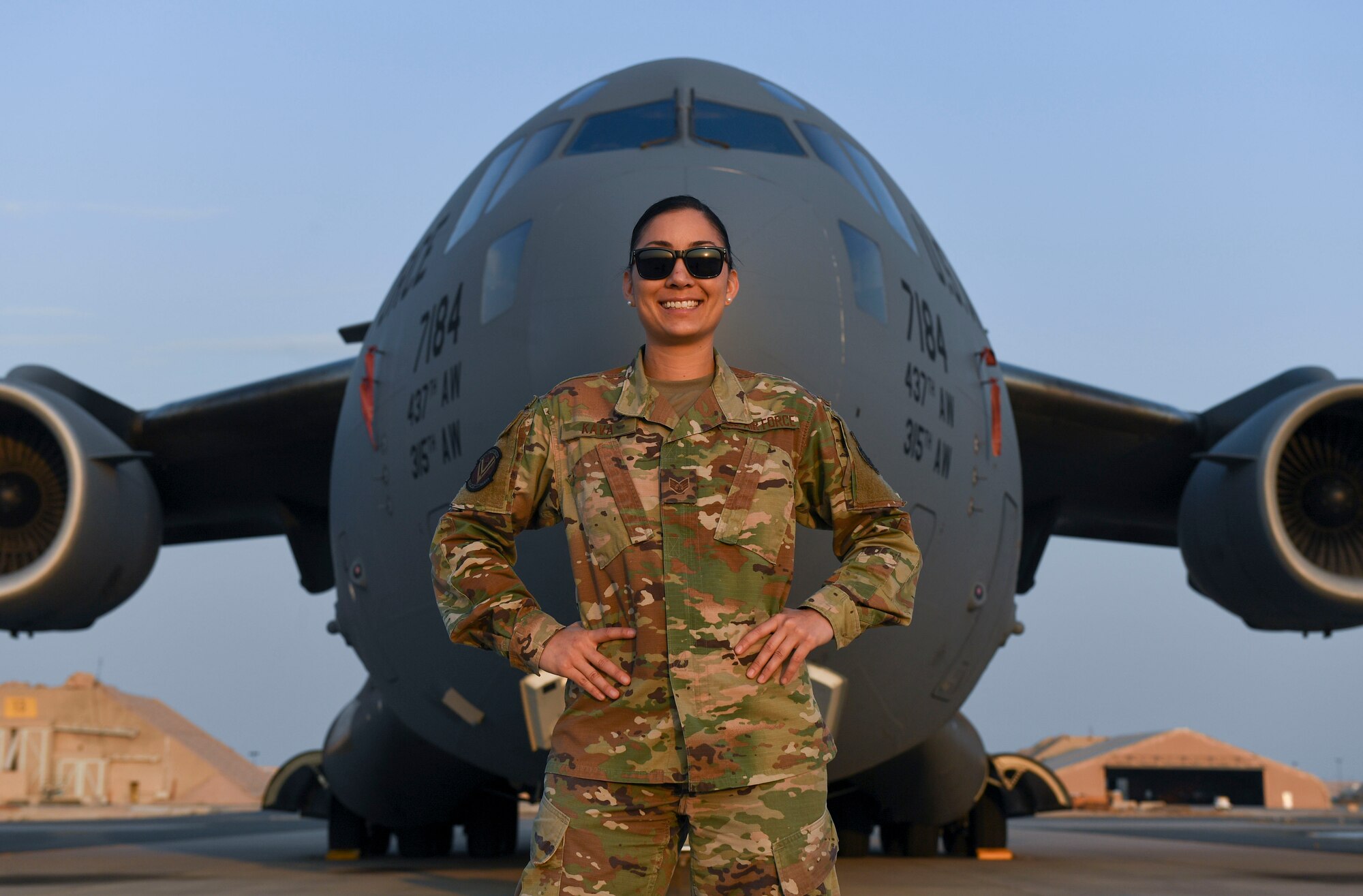 U.S. Air Force Staff Sgt. Cinnamon Kava, 5th Expeditionary Air Mobility Squadron combat oriented support operations supply specialist, poses in front of a C-17 Globemaster III at Ali Al Salem Air Base, Kuwait, Nov. 19, 2020.
