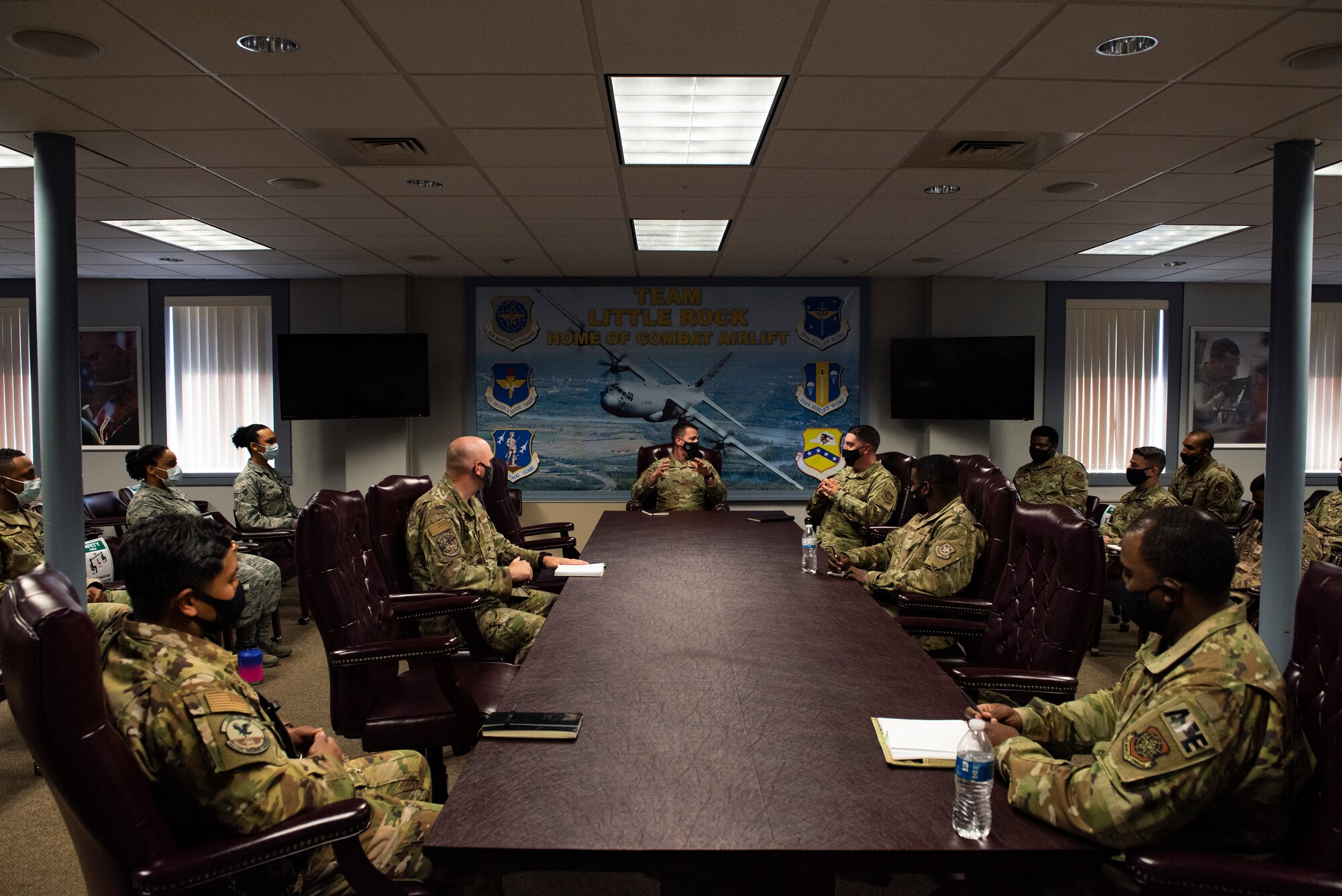 Men and women in conference room sitting around a table.