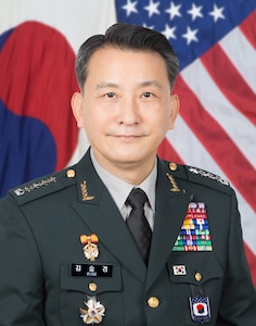 Gen. Kim Seung Kyum in uniform standing in front of the following flags (from left to right): South Korean flag and US flag.