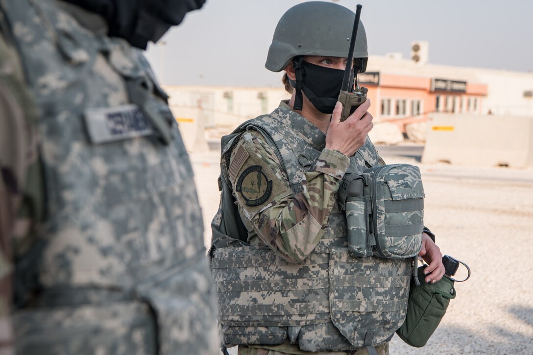 An Airman communicates through a handheld radio