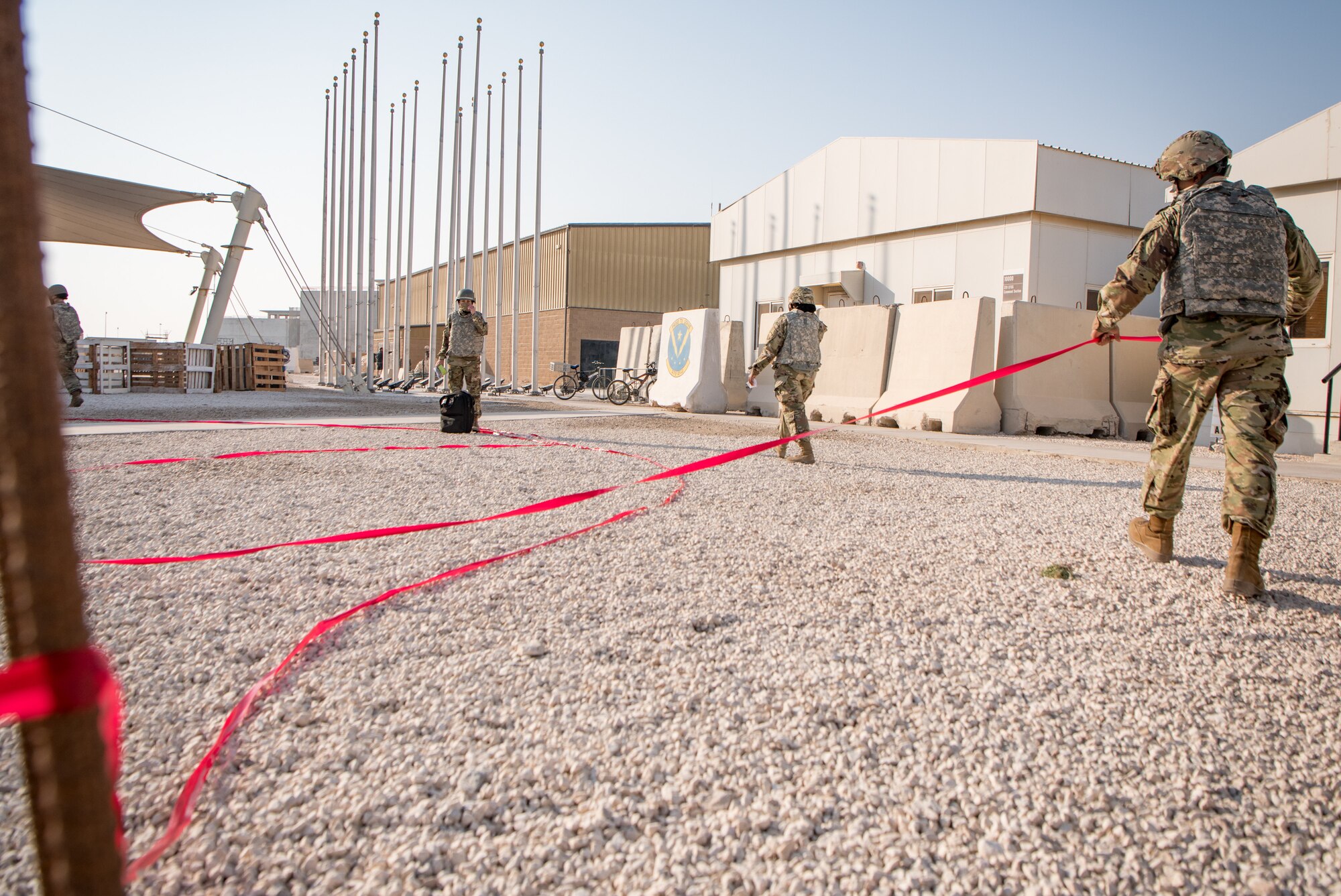 Airmen lay out red tape to mark a boundary