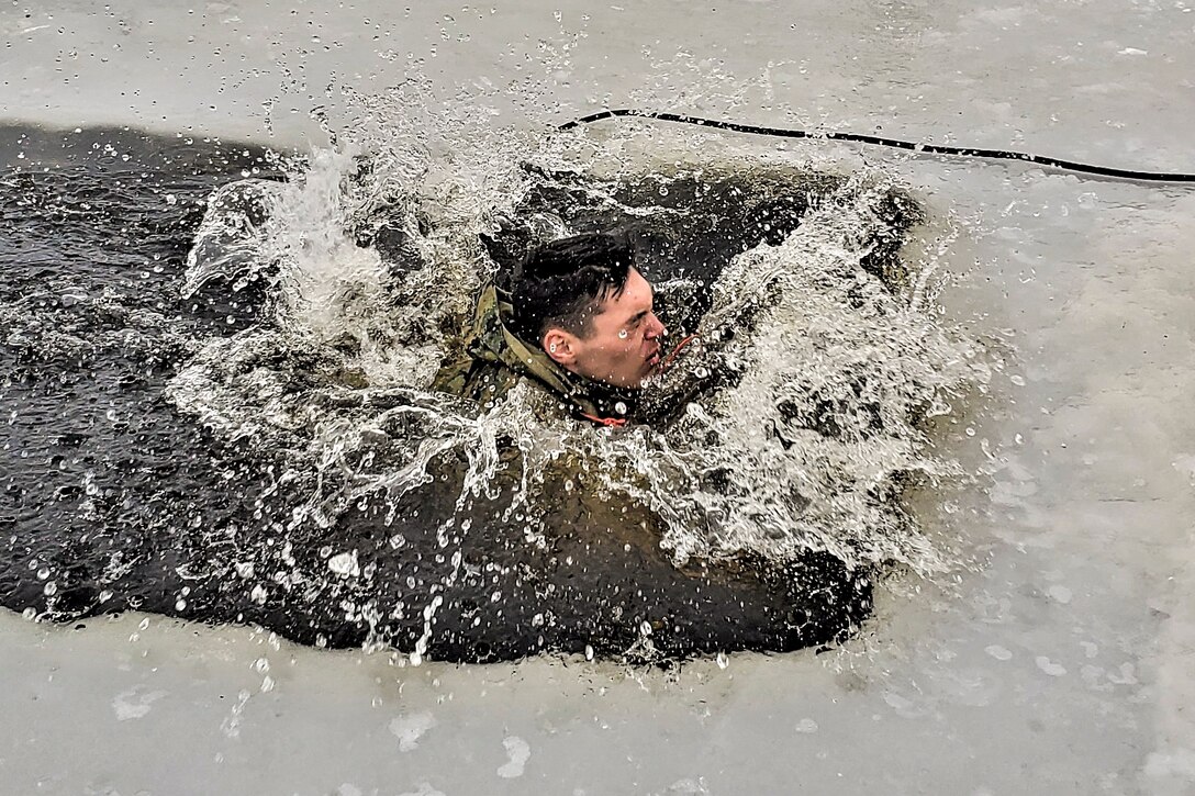 A student makes a splash while plunging into cold water.