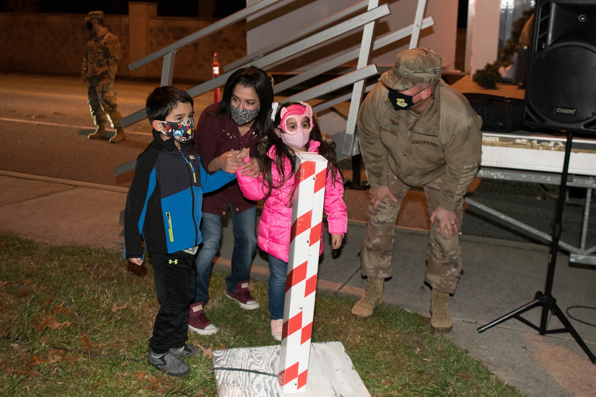 Col. Matthew Jones, 436th Airlift Wing commander and the family of currently deployed Tech Sgt. Timothy Solorio, 436th Civil Engineer Squadron firefighter, light the base Christmas tree Dec. 1, 2020, at Dover Air Force Base, Delaware. It’s a Dover AFB tradition to have the family of a deployed Airman light the Christmas tree. (U.S. Air Force photo by Mauricio Campino)