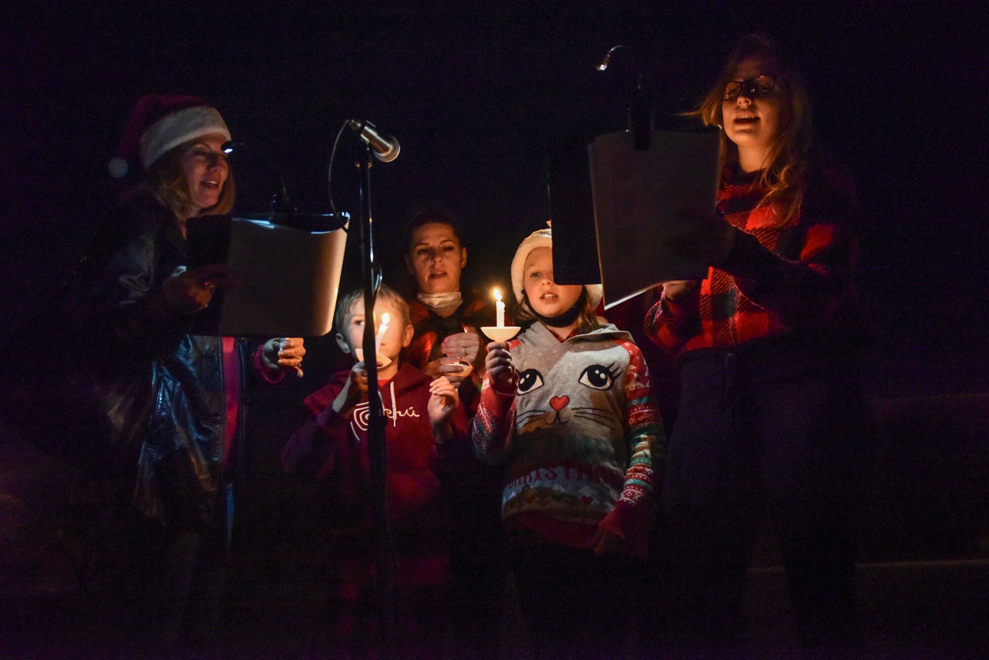 A picture of holiday carolers singing.