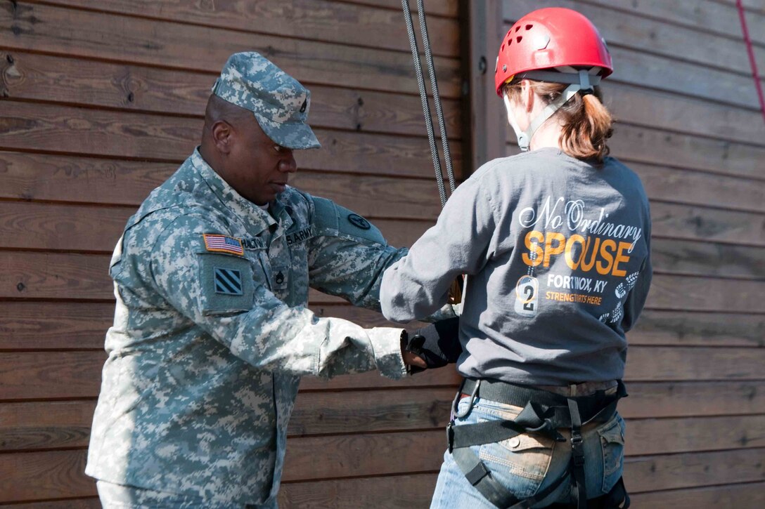 A man in a military uniform handles the cables attached to a woman who is in civilian clothing.