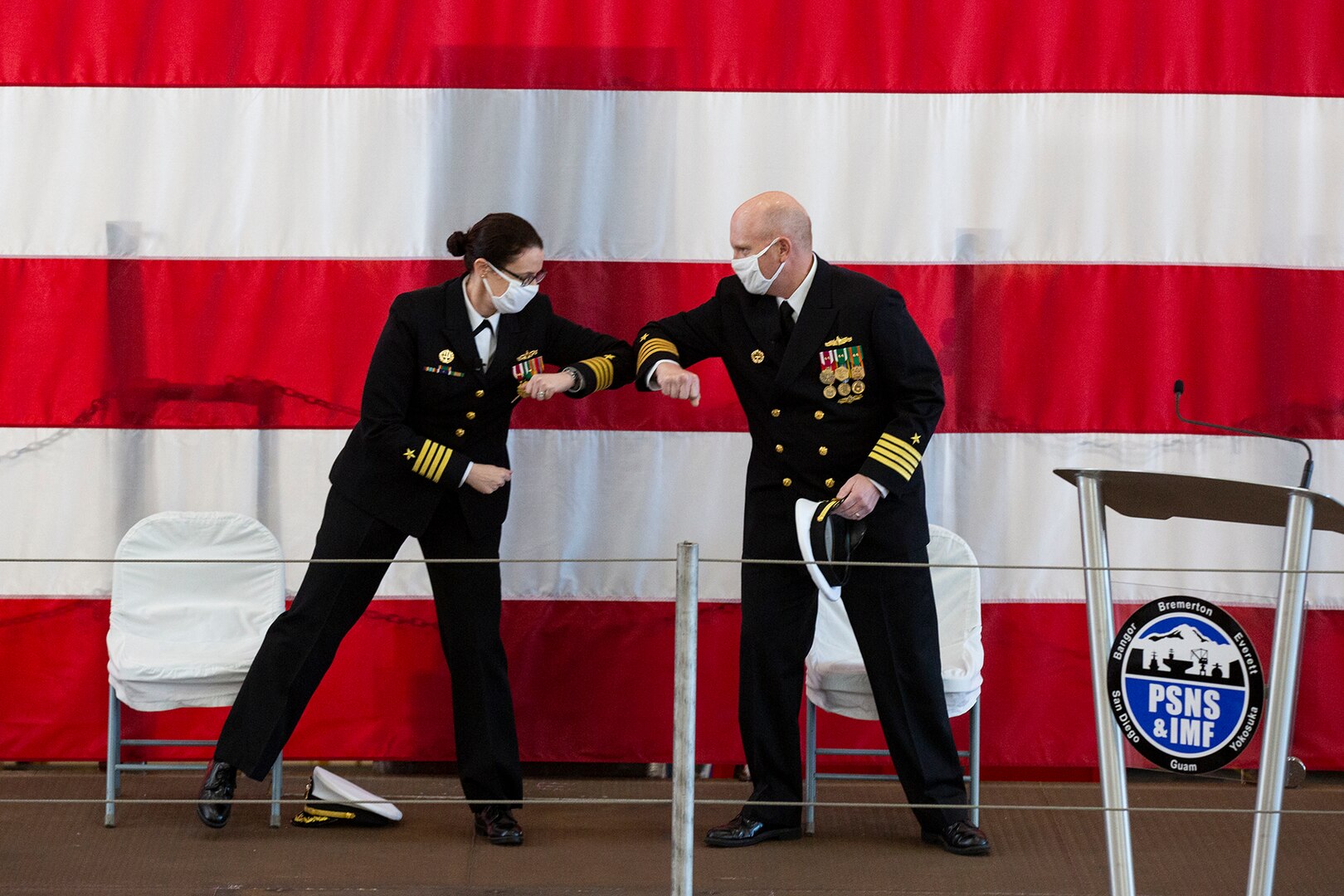 Puget Sound Naval Shipyard & Intermediate Maintenance Facility welcomed its new commander Dec. 2, 2020, at the shipyard in Bremerton, Washington, during a unique change of command ceremony that was arranged to protect participants and audience members from COVID-19. Capt. Jip Mosman relieved Capt. Dianna Wolfson during the ceremony in the historic Building 460. Vice Adm. William J. Galinis, commander, Naval Sea Systems Command, participated in the event via teleconference from NAVSEA headquarters in Washington, D.C. (PSNS & IMF photo by Carie Hagins)