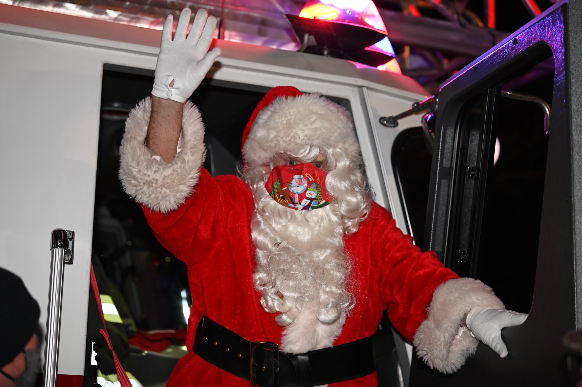 Santa Claus exits a firetruck during the tree-lighting ceremony Dec. 1, 2020, at Chapel 2 on Dover Air Force Base, Delaware. The ceremony included a a Christmas concert, speeches from several Dover AFB leaders, a surprise visit from Santa Claus, and the lighting of the base Christmas tree. (U.S. Air Force photo by Airman Cydney Lee)