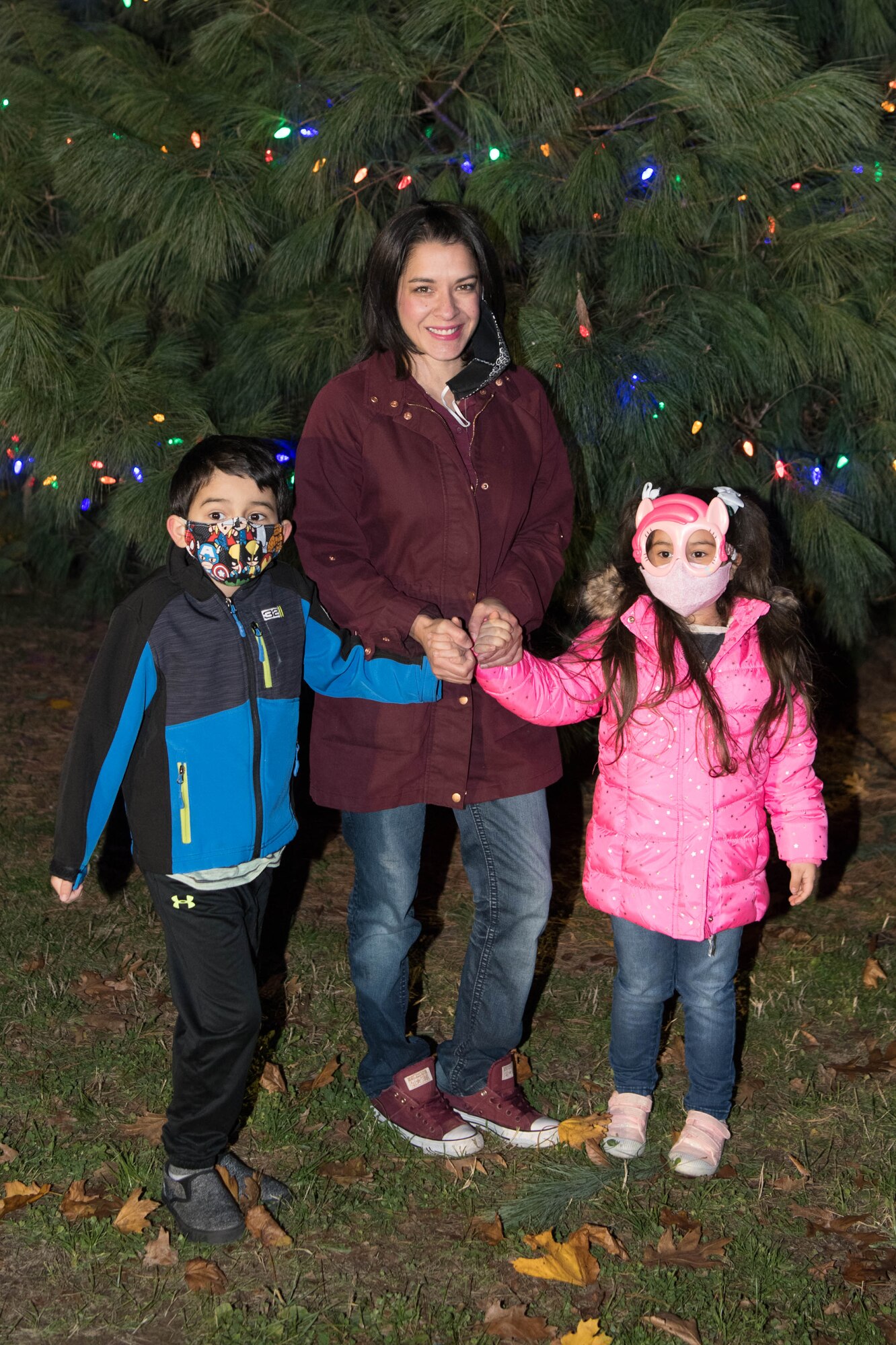 Naomi Solorio and her children T.J. and Lucy stand by the newly lit Christmas Tree at Dover Air Force Base, Delaware, Dec. 1, 2020. It’s a Dover AFB tradition to have the family of a deployed Airman light the Christmas tree. Tech Sgt. Timothy Solorio, 436th Civil Engineer Squadron firefighter is currently deployed overseas. (U.S. Air Force photo by Mauricio Campino)