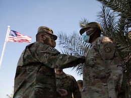 U.S. Army Lt. Gen. Terry Ferrell, commanding general at U.S. Army Central, shares a heartfelt moment with U.S. Army Col. James O. Oyekan, command surgeon, Area Support Group - Kuwait, during a coin ceremony held on Camp Arifjan, Kuwait, November 18, 2020. Ferrell presented Oyekan with the commander's Coin of Excellence for his distinguished leadership providing life-saving force health protection guidance throughout the COVID -19 public health emergency. (U.S. Army Reserve photo by Sgt. Khylee Woodford)