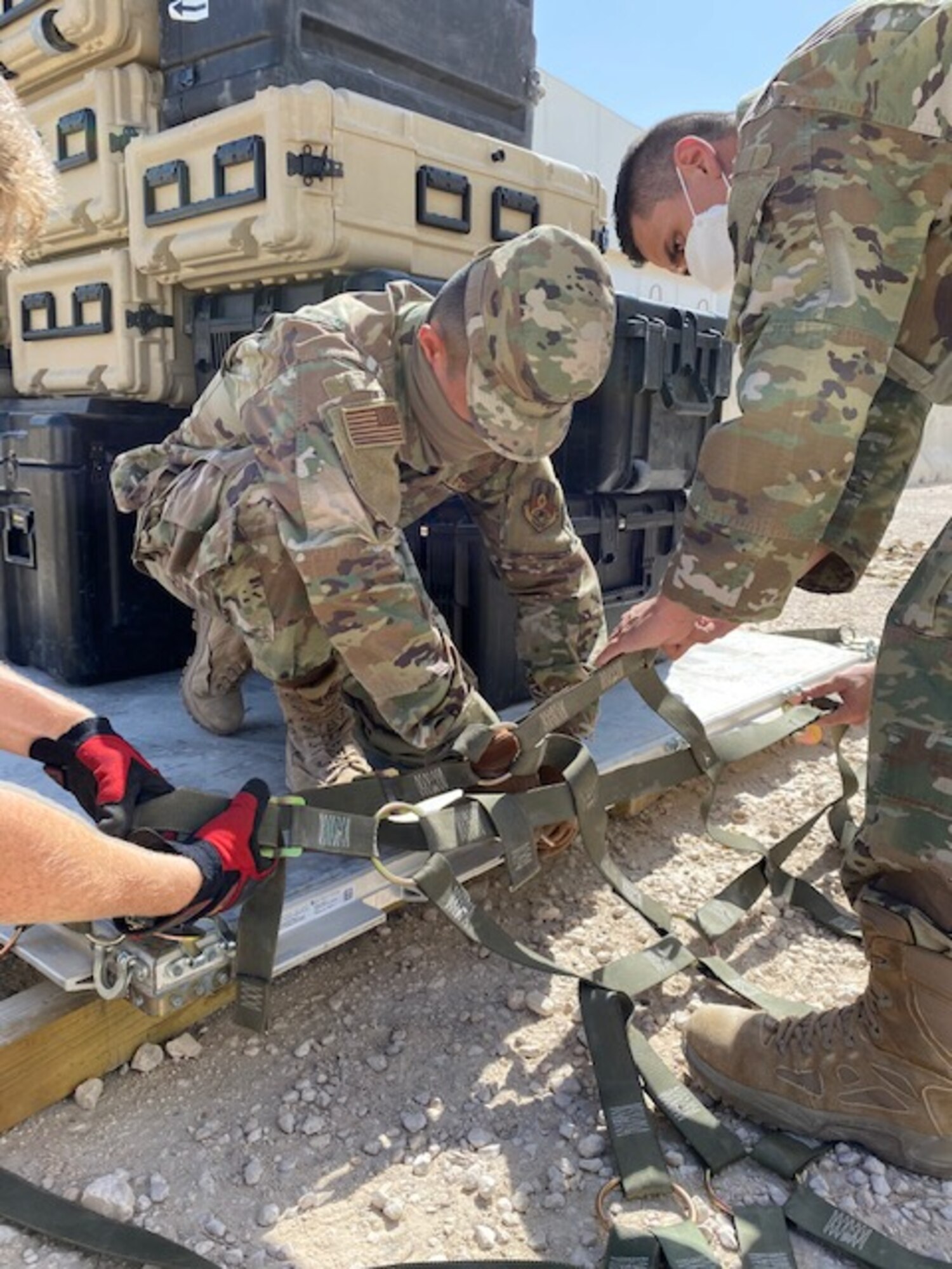 U.S. Air Force Airman 1st Class Albert Nofuente and Staff Sgt. Kazuhito Ikematsu, assigned to the 379th Expeditionary Communication Squadron at Al Udeid Air Base, Qatar, secure communications equipment onto a cargo pallet Oct. 9, 2020. The 379th ECS collaborated with the 379th Expeditionary Logistics Readiness Squadron to train on how to effectively load and transport communication equipment in the event of a real-world emergency where they would need it at an alternate location. (U.S. Air Force courtesy photo)
