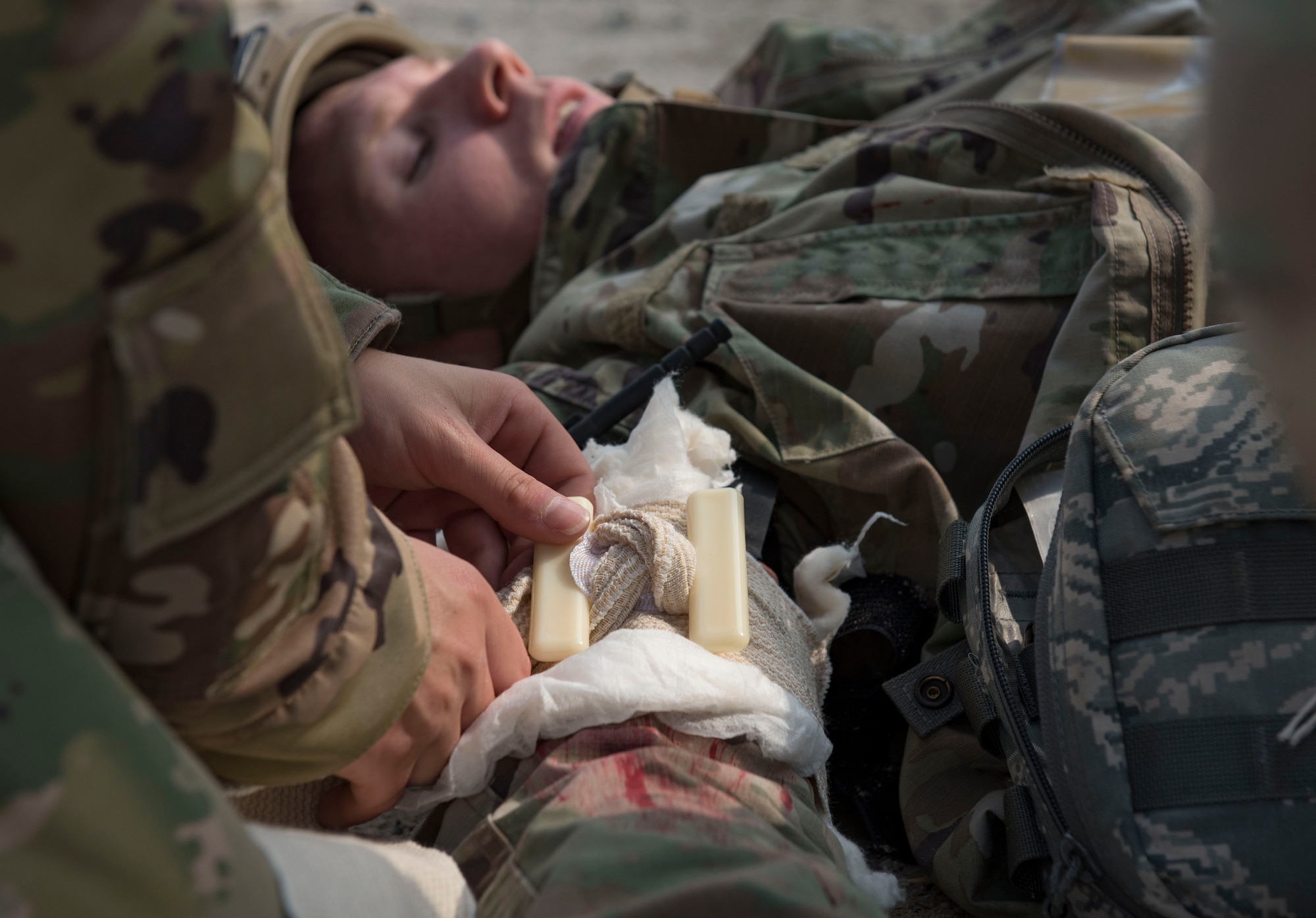 U.S. Air Force Master Sgt. Jeffrey Gordon, 386th Expeditionary Security Forces Squadron noncommissioned officer in charge of training, acts as a victim in need of care in the field during an improvised explosive device and unexploded ordnance familiarization course at Ali Al Salem Air Base, Kuwait, Dec. 2, 2020.