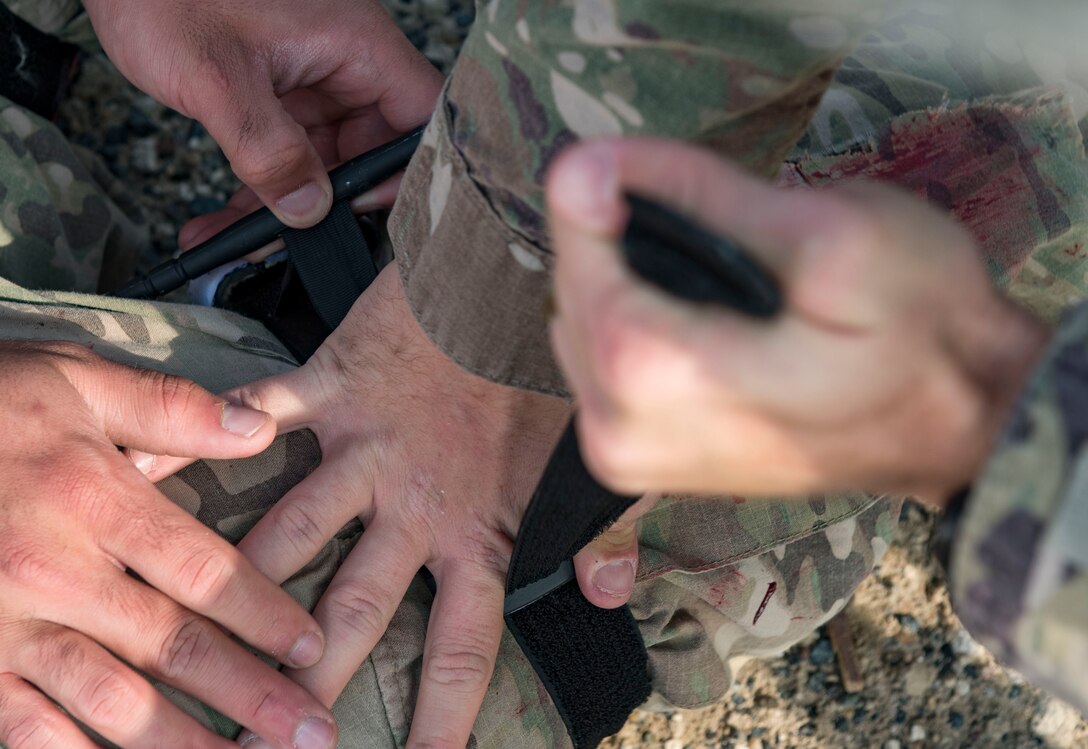 U.S. Air Force Airmen assigned to the 386th Expeditionary Security Forces Squadron apply a tourniquet during an improvised explosive device and unexploded ordnance familiarization course at Ali Al Salem Air Base, Kuwait, Dec. 2, 2020.