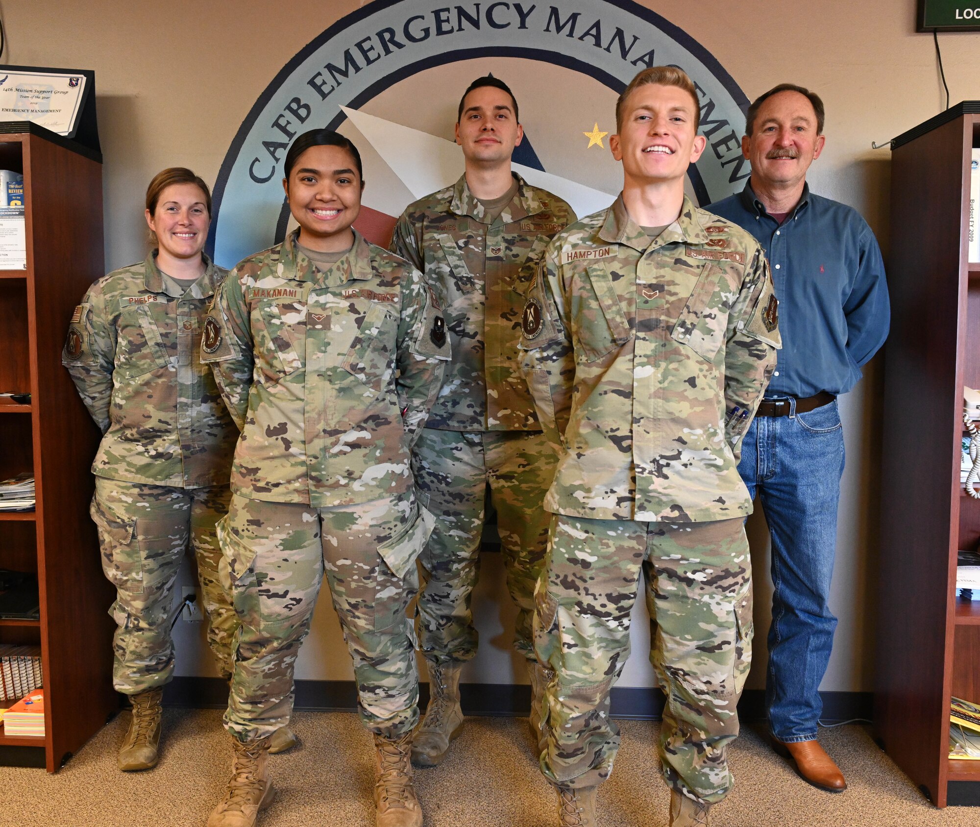The 14th Civil Engineer Squadron Readiness and Emergency Management flight stands in front of their logo Nov. 24, 2020, on Columbus Air Force Base, Miss. The R&EM flight won the Major Command level Col. Frederick J. Reimer Award which honors the lifetime accomplishments of the man considered to be the founder of Disaster Preparedness and a pioneer of the Air Force’s current Readiness Program. (U.S. Air Force photo by Senior Airman Jake Jacobsen)