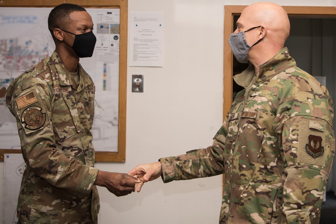 U.S. Air Force Staff Sgt. Marquette Richardson, 786th Civil Engineer Squadron facility excellence leadership team noncommissioned officer in charge, left, accepts a coin from U.S. Air Force Brig. Gen. Joshua Olson, 86th Airlift Wing commander, during an Airlifter of the Week ceremony.