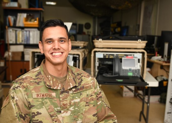 U.S. Air Force Staff Sgt. Kazuhito Ikematsu, noncommissioned officer in charge of the 379th Expeditionary Communication Squadron, sits for a portrait alongside mobile communication kits at Al Udeid Air Base, Qatar, Nov. 24, 2020. Ikematsu is responsible for coordinating training within his unit and externally with other entities on base, enhancing agile communication capabilities throughout the U.S. Air Forces Central area of responsibility. (U.S. Air Force photo by Staff Sgt. Kayla White)