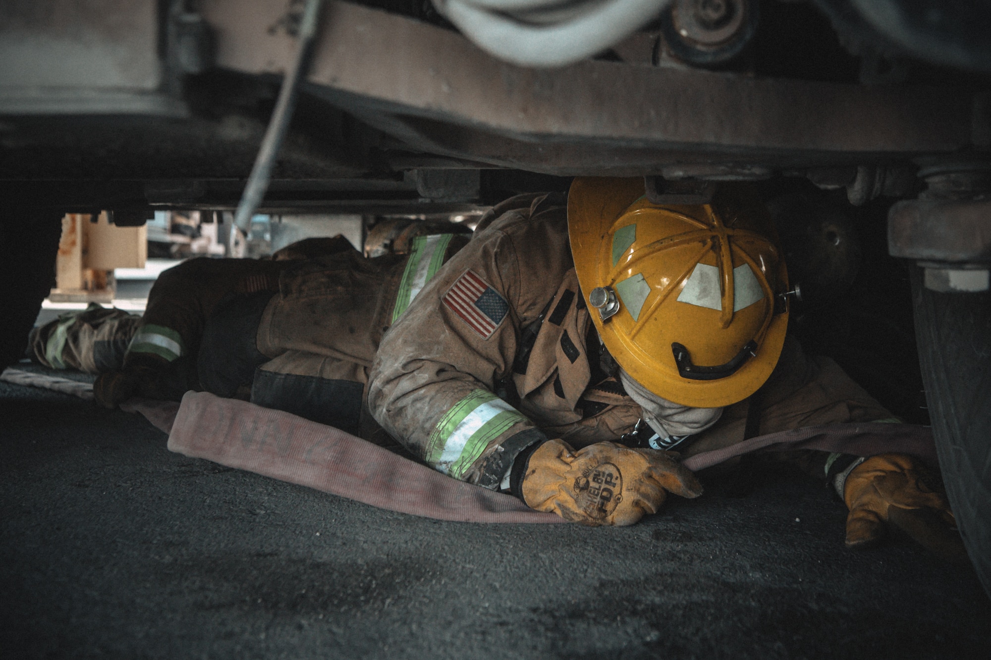 Fighting through a cramped space, Senior Airman Nyell Sanchez, a medical logistics technician in the 379th Expeditionary Medical Group, works blindfolded to traverse through a confined spaces obstacle course at Al Udeid Air Base, Qatar, Nov. 13, 2020. Sanchez participated in the Firefighter for a Day program hosted by the Al Udeid AB fire department. The program puts participants through physical and mental challenges that mimic what firefighters are trained and expected to do in emergency situations. Not only does the experience allow volunteers to better understand and appreciate firefighters, but it helps build cohesion among members of  Al Udeid AB allowing everyone to better complete the CENTCOM mission and posture to prevail tomorrow. (U.S. Air National Guard photo by Staff Sgt. Jordan Martin)