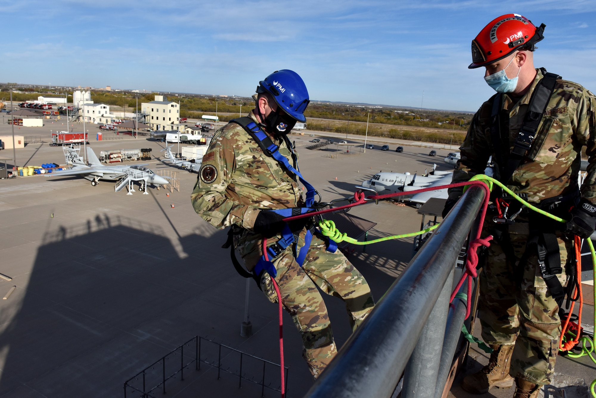 U.S. Air Force Maj. Gen. William Spangenthal, Air Education and Training Command deputy commander, rappels down a trainer wall at the Department of Defense Louis F. Garland Fire Academy on Goodfellow Air Force Base, Texas, Dec. 1, 2020, with the assistance of Tech. Sgt. James Mullenix, 312th Training Squadron instructor. Spangenthal participated in several demonstrations while visiting Goodfellow. (U.S. Air Force photo by Staff Sgt. Seraiah Wolf)