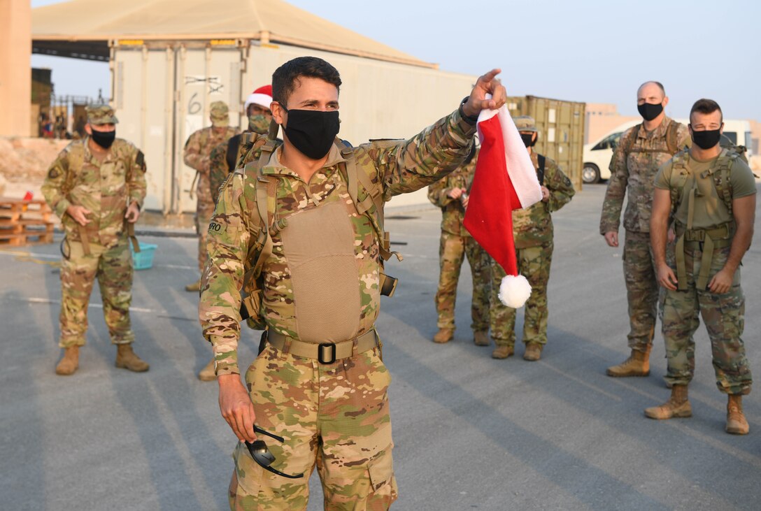 U.S. Army 1st Lt. Keven Cordero, executive officer for the headquarters support element of U.S. Forces Afghanistan, explains the route for the Christmas Ration Ruck March to deployed Airmen, Soldiers, Sailors and Marines on Dec. 1, 2020, at Al Udeid Air Base, Qatar. Cordero organized the charitable event, which brought the combined team of U.S. military members together and partnered with the USO to donate toiletries, children's books and food items back to the United States. (U.S. Air Force photo by Staff Sgt. Kayla White)