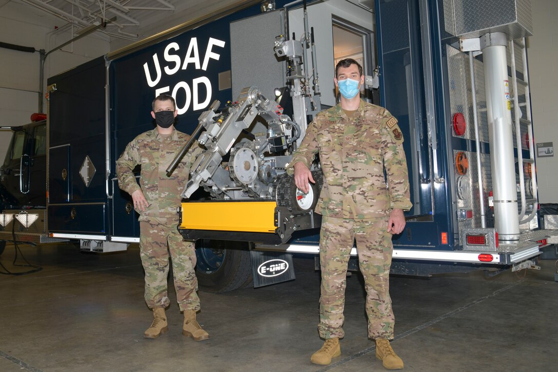 U.S. Air Force Tech. Sgts. Kenneth Dunn, Thomas Gilbert, 509th Civil Engineer Squadron Explosive Ordnance Disposal technicians, stand for a photo next to the installed wheelchair lift July 14, 2020, at Whiteman Air Force Base, Missouri. The EOD flight used squadron innovation funds to purchase the lift. The new lift saves time and man power by reducing the number of people needed to retrieve the Counter Improvised Explosive Device robot. (U.S. Air Force photo by Staff Sgt. Dylan Nuckolls)