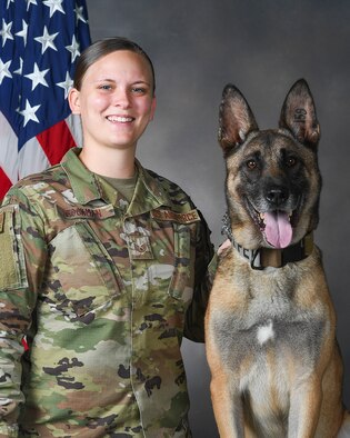 Military Working Dog Rudo’s official photo with his last handler, Staff Sgt. Lacey Bockman, 88th Security Forces Squadron, taken July 22, 2020, in the Wright-Patterson Air Force Base, Ohio, photography studio. Bockman has applied to adopt Rudo now that he has been retired. (U.S. Air Force photo by R.J. Oriez)