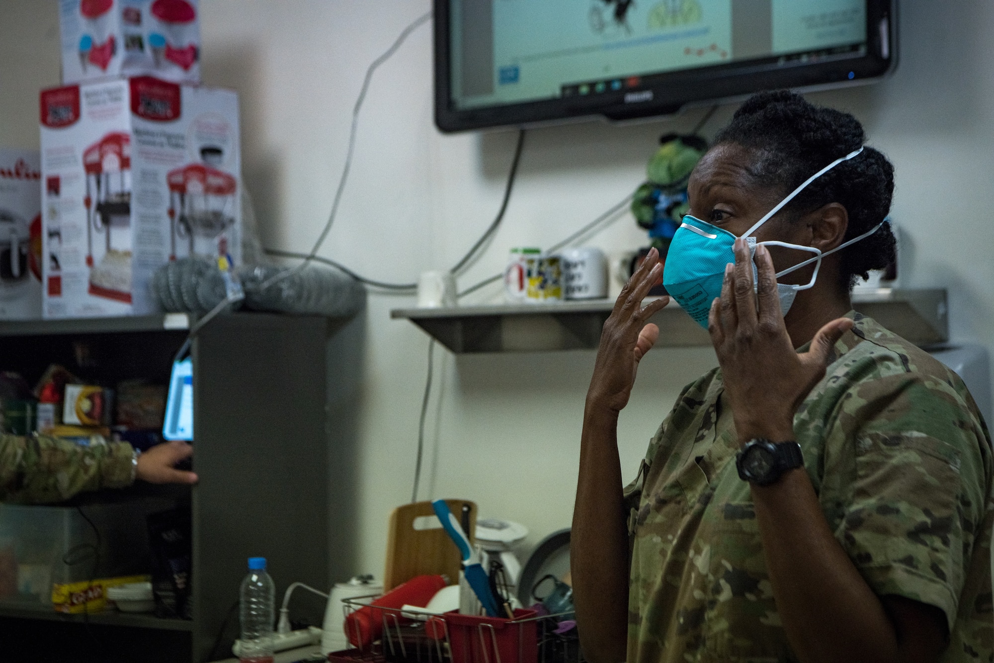 Airman demonstrates how to put on N95 mask properly