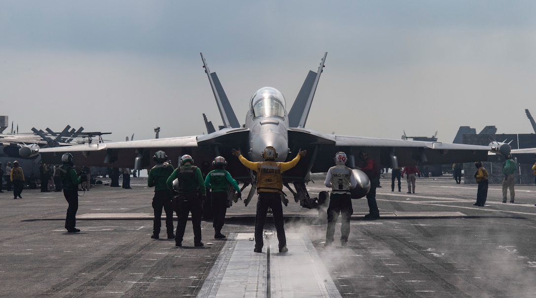 NORTH ARABIAN SEA (Dec. 2, 2020) A Sailor directs an E/A-18G Growler, from the “Cougars” of Electronic Attack Squadron (VAQ) 139, on the flight deck of the aircraft carrier USS Nimitz (CVN 68). Nimitz, the flagship of Nimitz Carrier Strike Group, is deployed to the U.S. 5th Fleet area of operations to ensure maritime stability and security in the Central Region, connecting the Mediterranean and Pacific through the Western Indian Ocean and three critical chokepoints to the free flow of global commerce. (U.S. Navy photo by Mass Communication Specialist 3rd Class Cheyenne Geletka/Released)