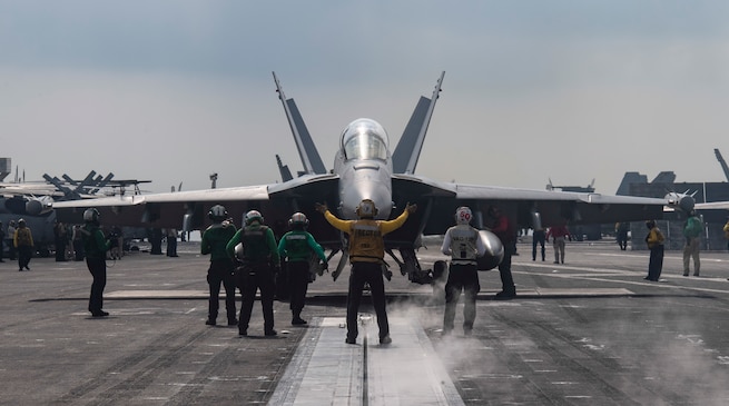 NORTH ARABIAN SEA (Dec. 2, 2020) A Sailor directs an E/A-18G Growler, from the “Cougars” of Electronic Attack Squadron (VAQ) 139, on the flight deck of the aircraft carrier USS Nimitz (CVN 68). Nimitz, the flagship of Nimitz Carrier Strike Group, is deployed to the U.S. 5th Fleet area of operations to ensure maritime stability and security in the Central Region, connecting the Mediterranean and Pacific through the Western Indian Ocean and three critical chokepoints to the free flow of global commerce. (U.S. Navy photo by Mass Communication Specialist 3rd Class Cheyenne Geletka/Released)