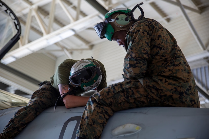 Maintainers work on an aircraft.