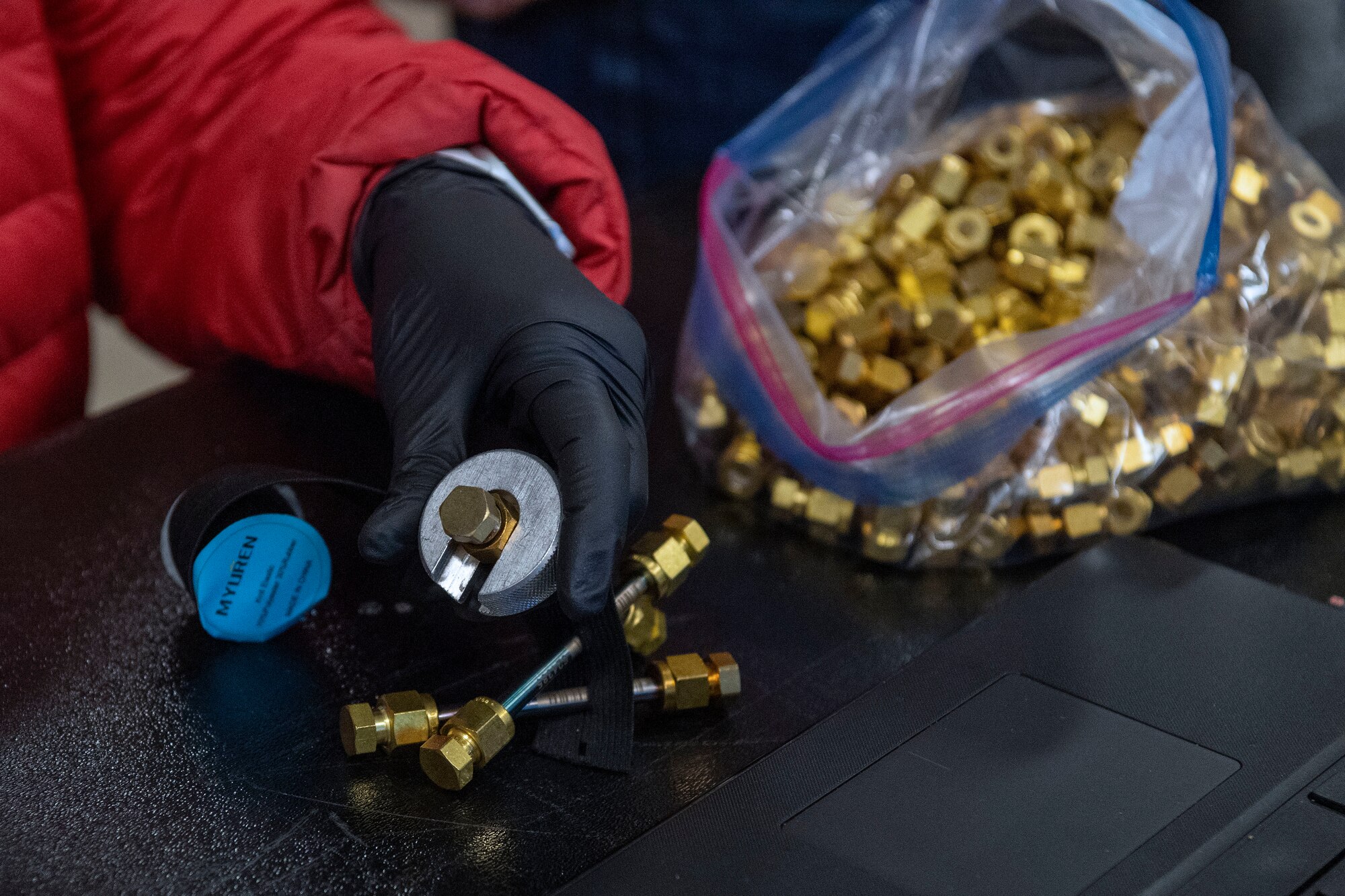 Picture of hand working with screws, nuts and bolts