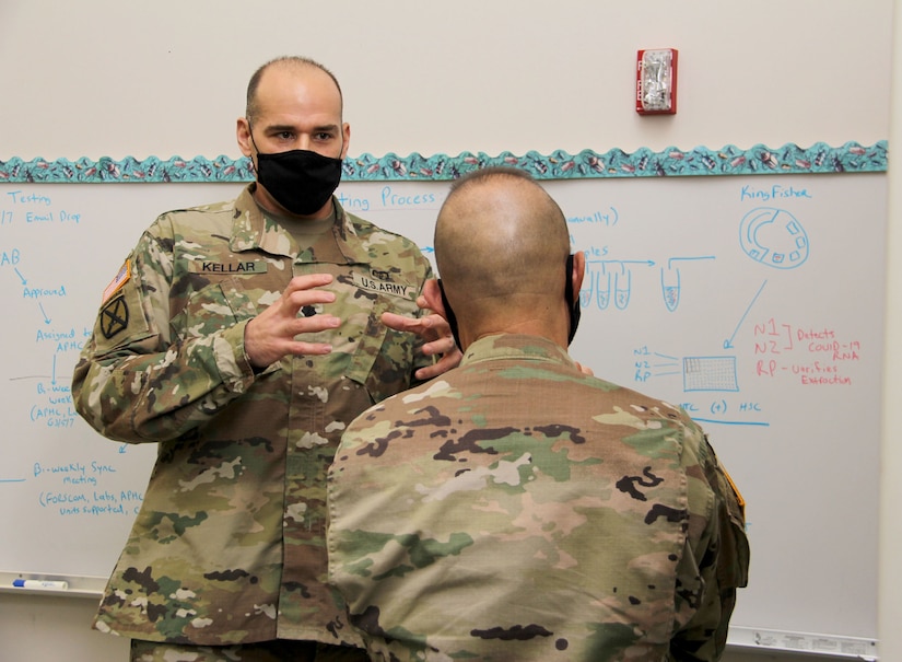 Lt. Col. Gerald Kellar, a microbiologist assigned to Public Health Command-Pacific’s branch at Joint Base Lewis-McChord, Washington, explains the command’s new COVID-19 pooled testing procedures to Brig. Gen. Jack M. Davis, commanding general of Regional Health Command-Pacific, at PHC-P’s new COVID-19 Surveillance Testing Laboratory, Dec. 3, 2020. (U.S. Army photo by Christopher Larsen, RHC-P Public Affairs)