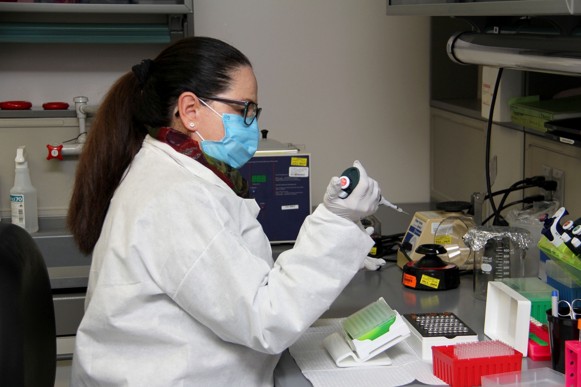 Milagros Sola, a microbiologist with Pubic Health Command-Pacific, works with ribonucleic acid, or RNA, while demonstrating the command’s new COVID-19 pooled testing procedures to Brig. Gen. Jack M. Davis, commanding general of Regional Health Command-Pacific, at PHC-P’s new COVID-19 Surveillance Testing Laboratory, Dec. 3, 2020. (U.S. Army photo by Christopher Larsen, RHC-P Public Affairs)