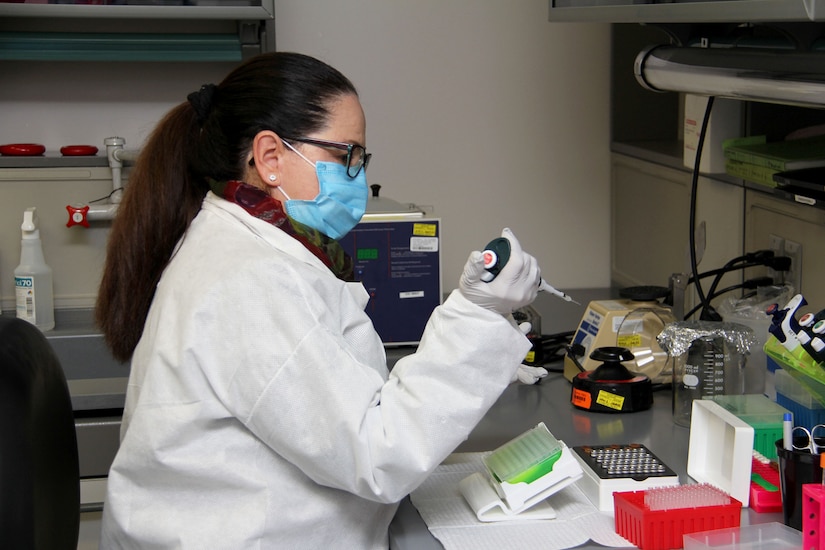 Milagros Sola, a microbiologist with Pubic Health Command-Pacific, works with ribonucleic acid, or RNA, while demonstrating the command’s new COVID-19 pooled testing procedures to Brig. Gen. Jack M. Davis, commanding general of Regional Health Command-Pacific, at PHC-P’s new COVID-19 Surveillance Testing Laboratory, Dec. 3, 2020. (U.S. Army photo by Christopher Larsen, RHC-P Public Affairs)