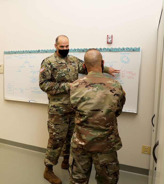 Lt. Col. Gerald Kellar, a microbiologist assigned to Public Health Command-Pacific’s Public Health Activity-Fort Lewis branch at Joint Base Lewis-McChord, Washington, explains the command’s new COVID-19 pooled testing procedures to Brig. Gen. Jack M. Davis, commanding general of Regional Health Command-Pacific, at PHC-P’s new COVID-19 Surveillance Testing Laboratory, Dec. 3, 2020. (U.S. Army photo by Christopher Larsen, RHC-P Public Affairs)