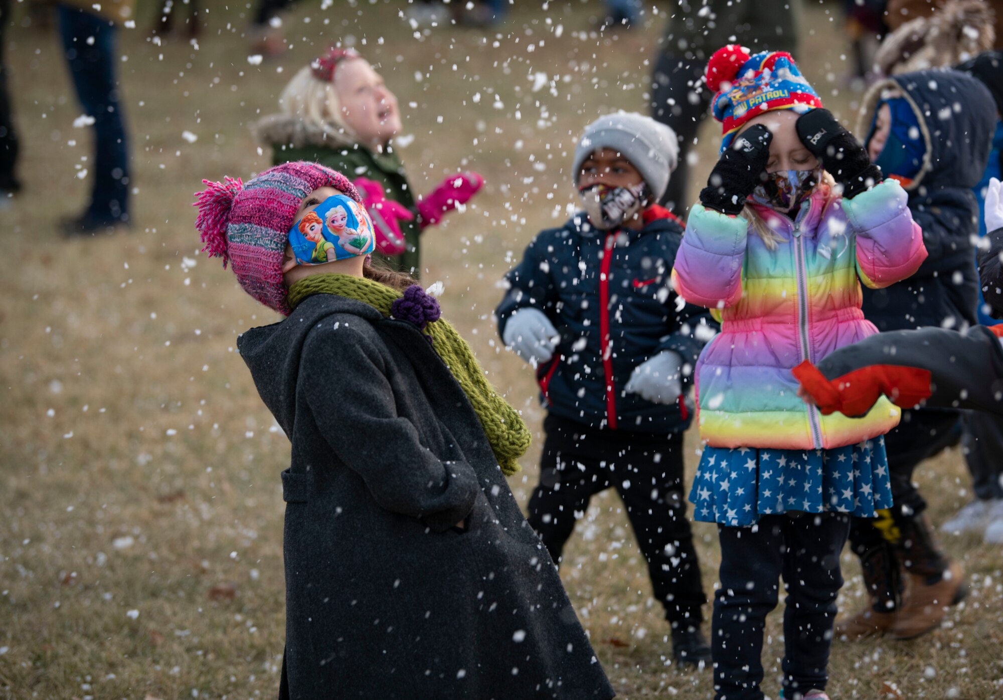 Children play in “snow” at the annual holiday tree lighting event, Dec. 3, 2020, at Altus Air Force Base, Oklahoma. The snow was made of soapsuds that were blown from a snow machine. (U.S. Air Force photo by Airman 1st Class Amanda Lovelace)