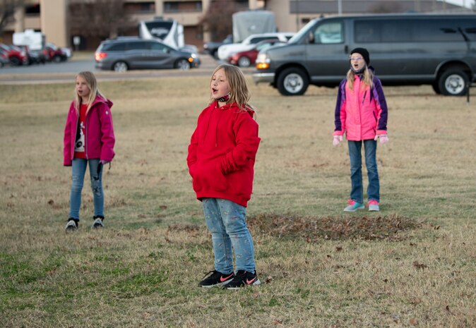 Children from the youth center sing during their performance at the annual holiday tree lighting event, Dec. 3, 2020, at Altus Air Force Base, Oklahoma. The children maintained a six-foot difference between each other and sang “Silent Night,” “What Child is This?,” and “Rudolph the Red-Nosed Reindeer.” (U.S. Air Force photo by Airman 1st Class Amanda Lovelace)