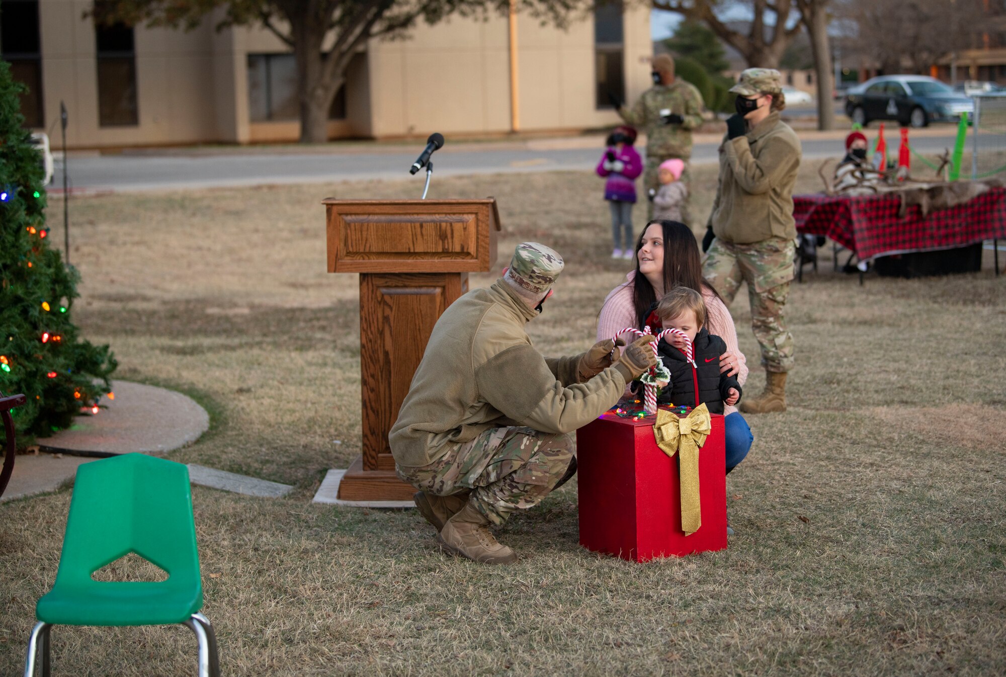 Kaitlynn Reinsch, the wife of Staff Sgt. Dakota Reinsch from the 97th Security Forces Squadron, their son, Ryan, and Col. David Vanderburg, 97th Mission Support Group commander, did the honors of activating the tree during the annual holiday tree lighting event, Dec. 3, 2020, at Altus Air Force Base, Oklahoma. Each year, a family of a deployed Airman is given the opportunity to join leadership in illuminating the lights on the tree. (U.S. Air Force photo by Airman 1st Class Amanda Lovelace)