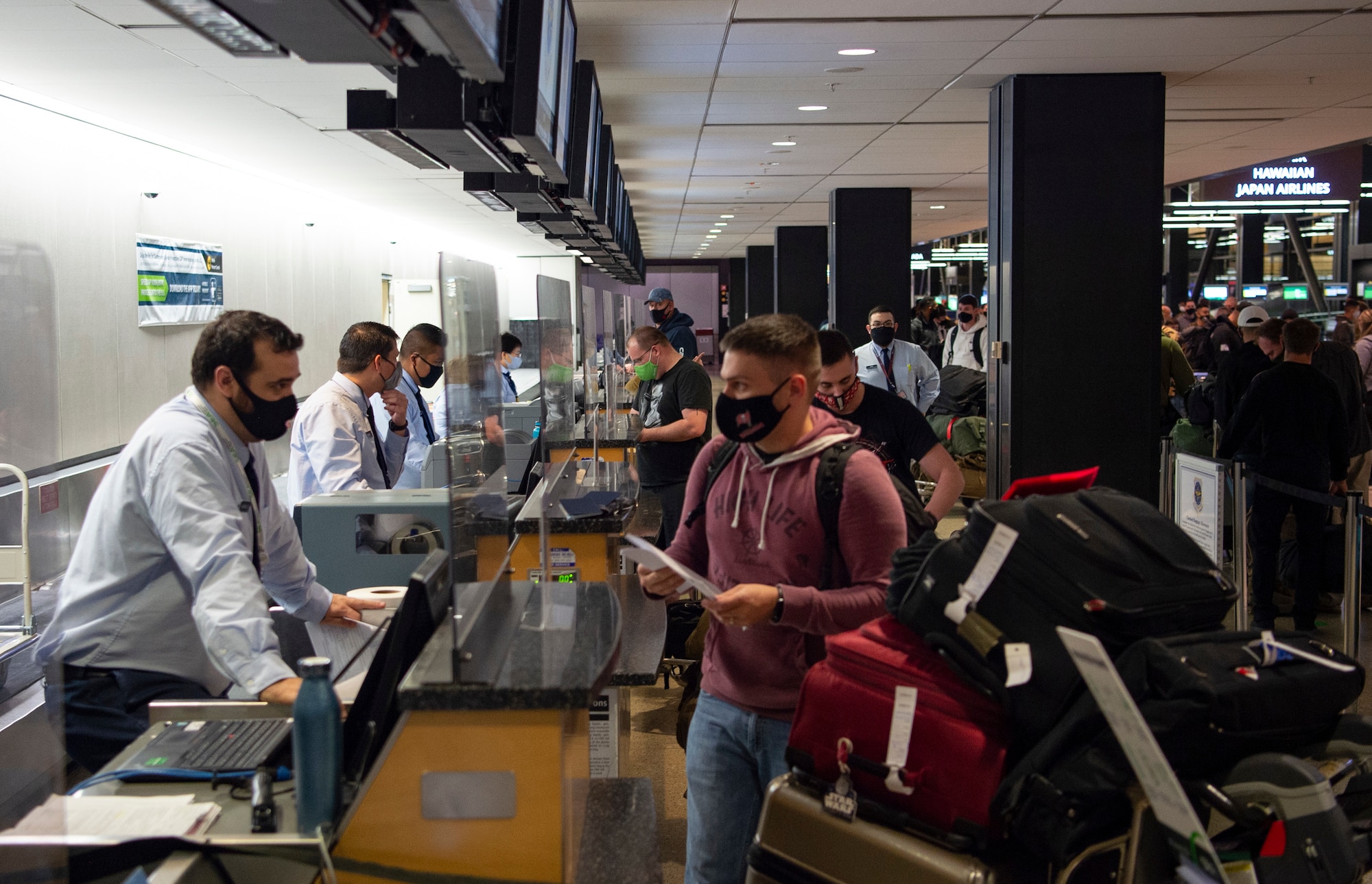 Passengers traveling through the Air Mobility Command terminal check in for their flight at the Seattle-Tacoma International Airport in Seattle, Dec. 3, 2020. To fly, passengers are required to wear masks, complete a medical questionnaire, and are subject to a random COVID-19 test. (U.S. Air Force photo by Senior Airman Tryphena Mayhugh)