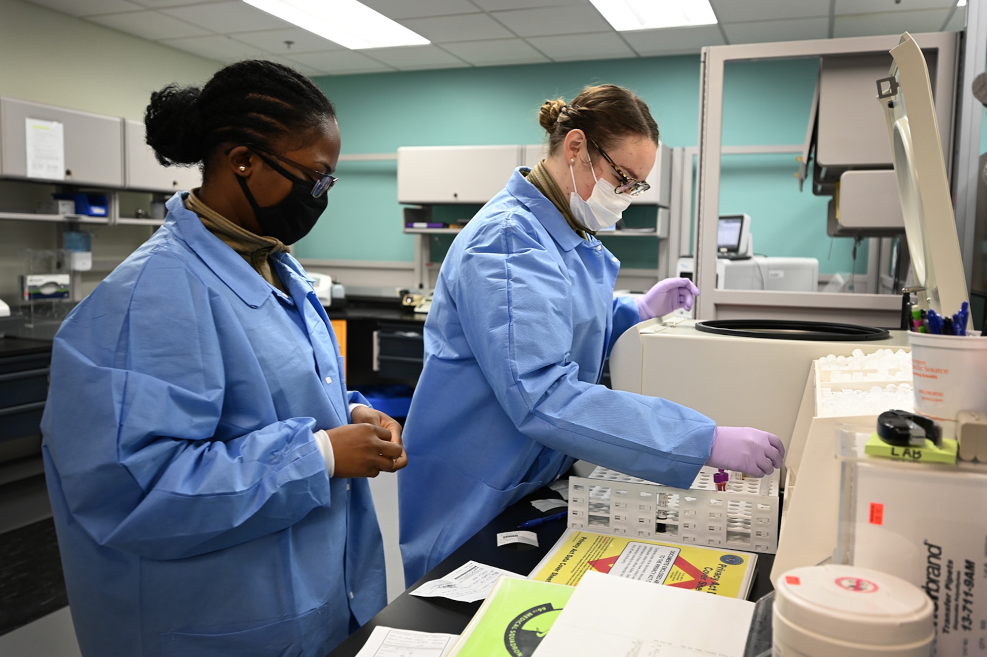 Senior Airman Arienthea Gray and Airman 1st Class Kaylin Rice, 66th Medical Squadron Laboratory technicians, record lab work results at the medical laboratory at Hanscom Air Force Base, Mass., Dec. 3. Laboratory technicians are responsible for collecting and testing all routine lab work and COVID tests done on the installation. (U.S. Air Force photo by Todd Maki)