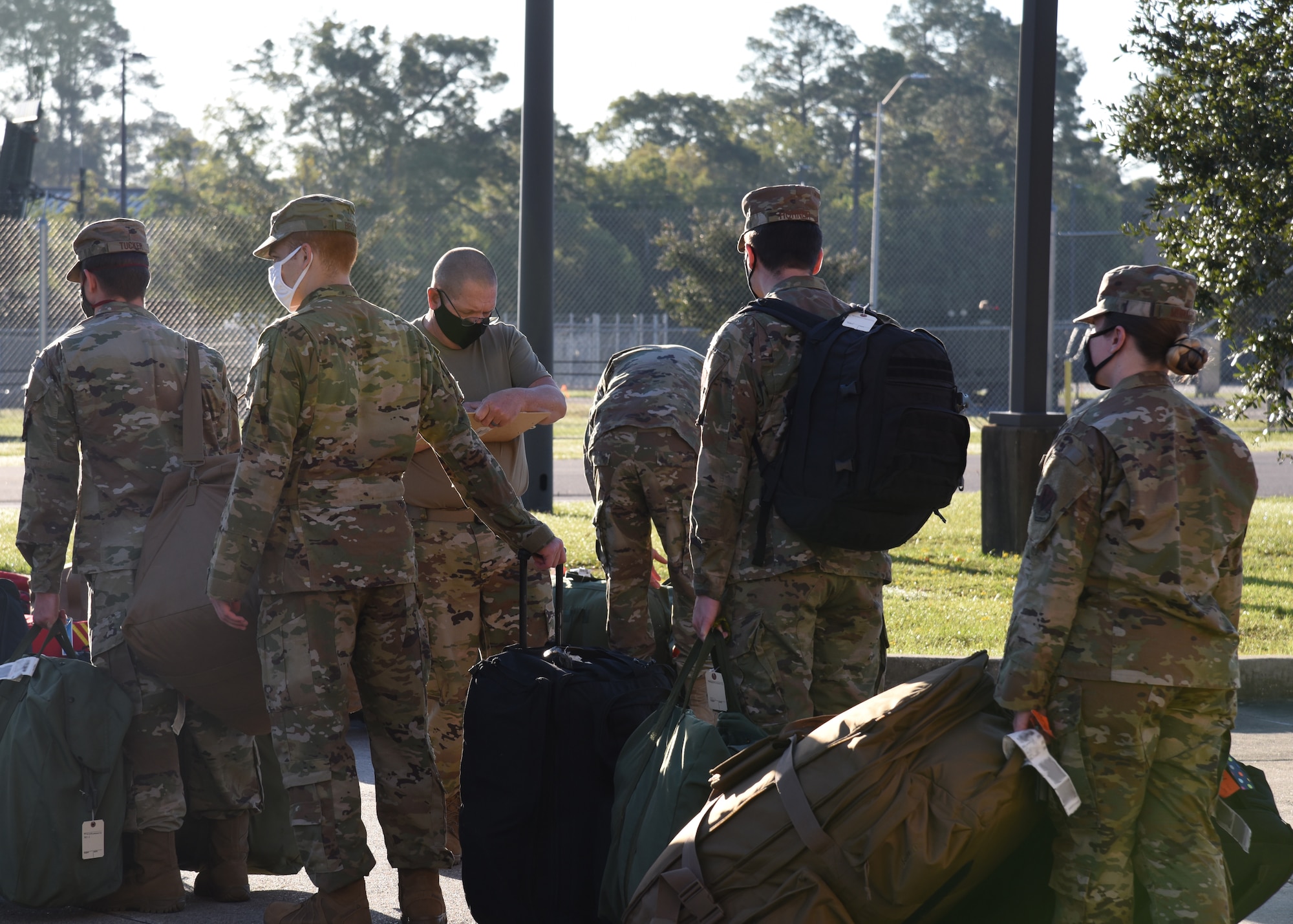 Members of the Air National Guard and the 403rd Wing work together loading bags onto a truck at Camp Gulfport, which is located at the Gulfport Combat Readiness Training Center, where one Restriction of Movement operation was set up in order to prevent the spread of COVID-19. ROMs were put into effect before all deployments start, in order to ensure the safety of service members in the U.S. Central, Africa, and European Commands area of responsibilty. (U.S. Air Force photo by Jessica L. Kendziorek)