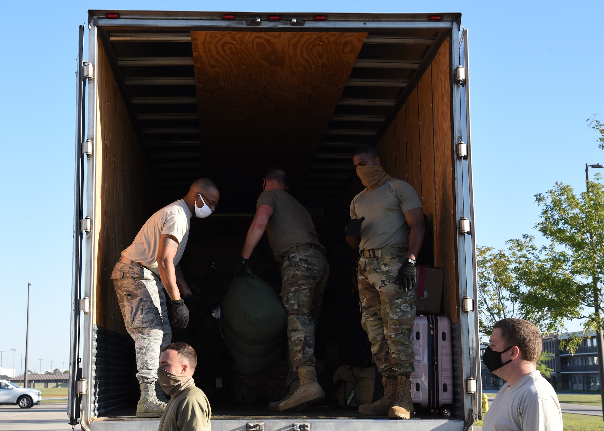 Members of the Air National Guard and the 403rd Wing work together loading bags onto a truck at Camp Gulfport, which is located at the Gulfport Combat Readiness Training Center, where one Restriction of Movement operation was set up in order to prevent the spread of COVID-19. ROMs were put into effect before all deployments start, in order to ensure the safety of service members in the U.S. Central, Africa, and European Commands area of responsibilty. (U.S. Air Force photo by Jessica L. Kendziorek)