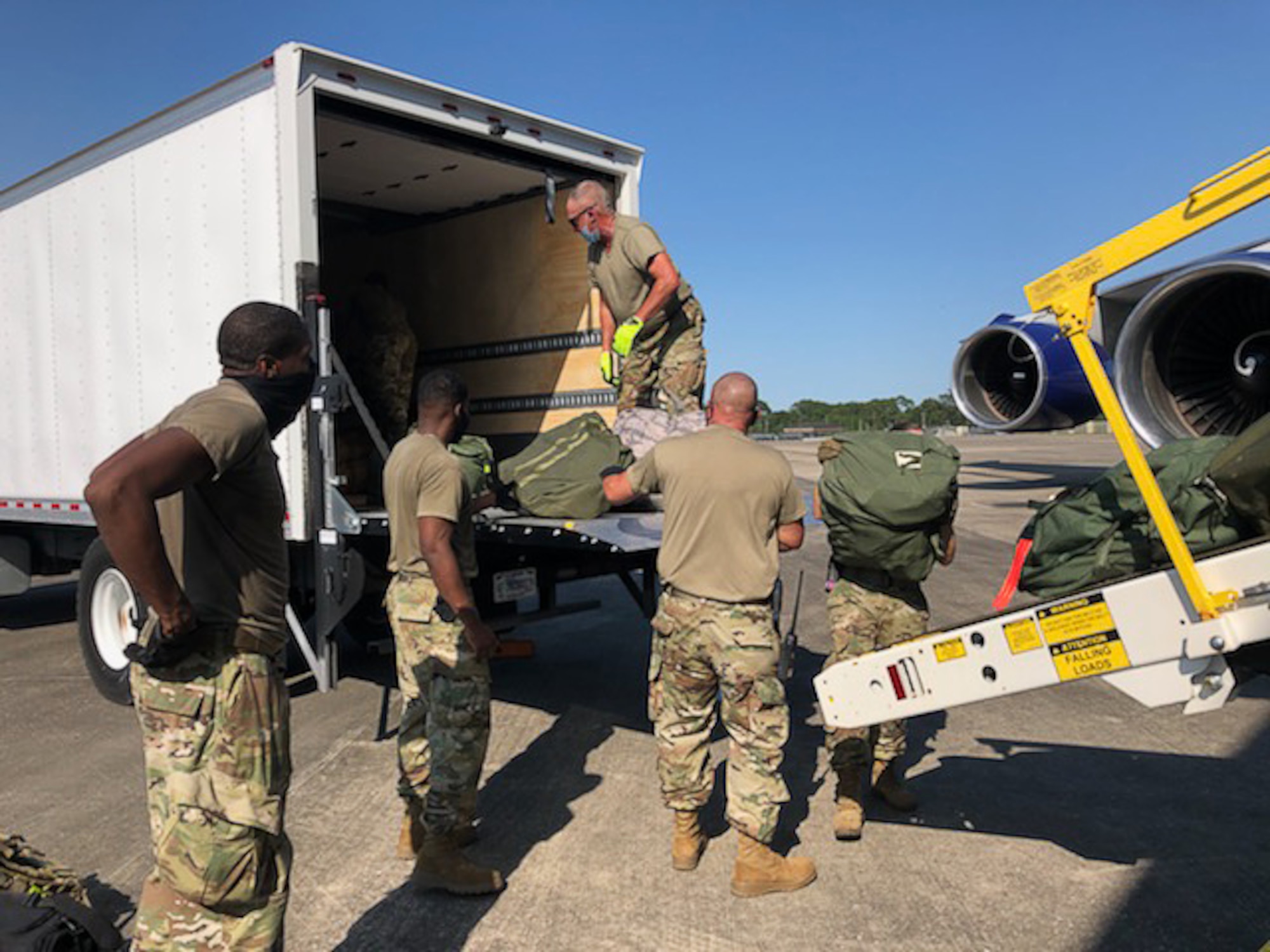 Members of the Air National Guard and the 403rd Wing work together loading bags onto the airplane with the deployers at Camp Gulfport, which is located at the Gulfport Combat Readiness Training Center, where one Restriction of Movement operation was set up in order to prevent the spread of COVID-19. ROMs were put into effect before all deployments start, in order to ensure the safety of service members in the U.S. Central, Africa, and European Commands area of responsibilty. (U.S. Air Force photo by Lt. Col. Shawn Baldy)