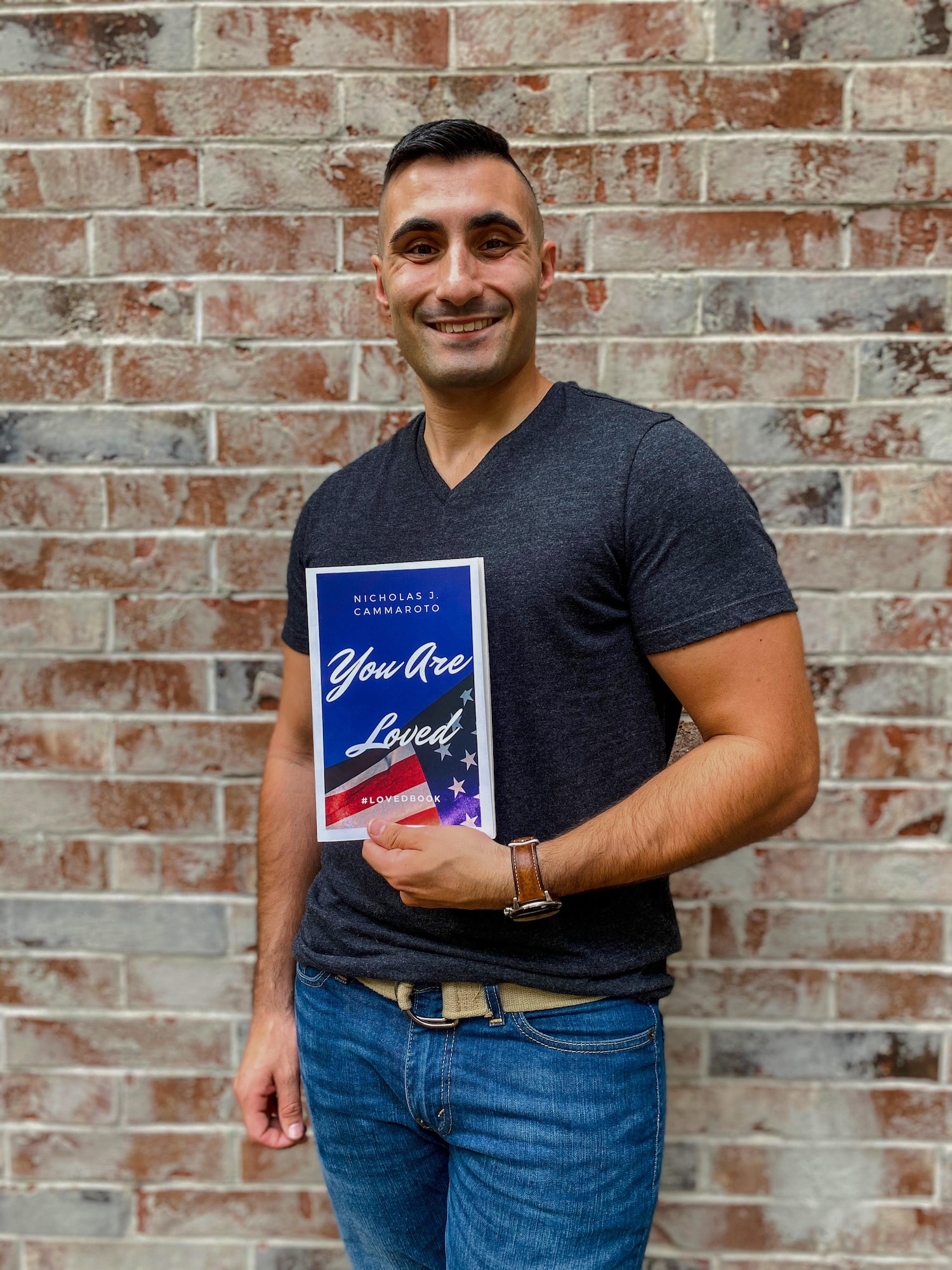 Air National Guard Senior Airman Nicholas Cammaroto poses with a copy of his recently published, debut book, “You Are Loved.”