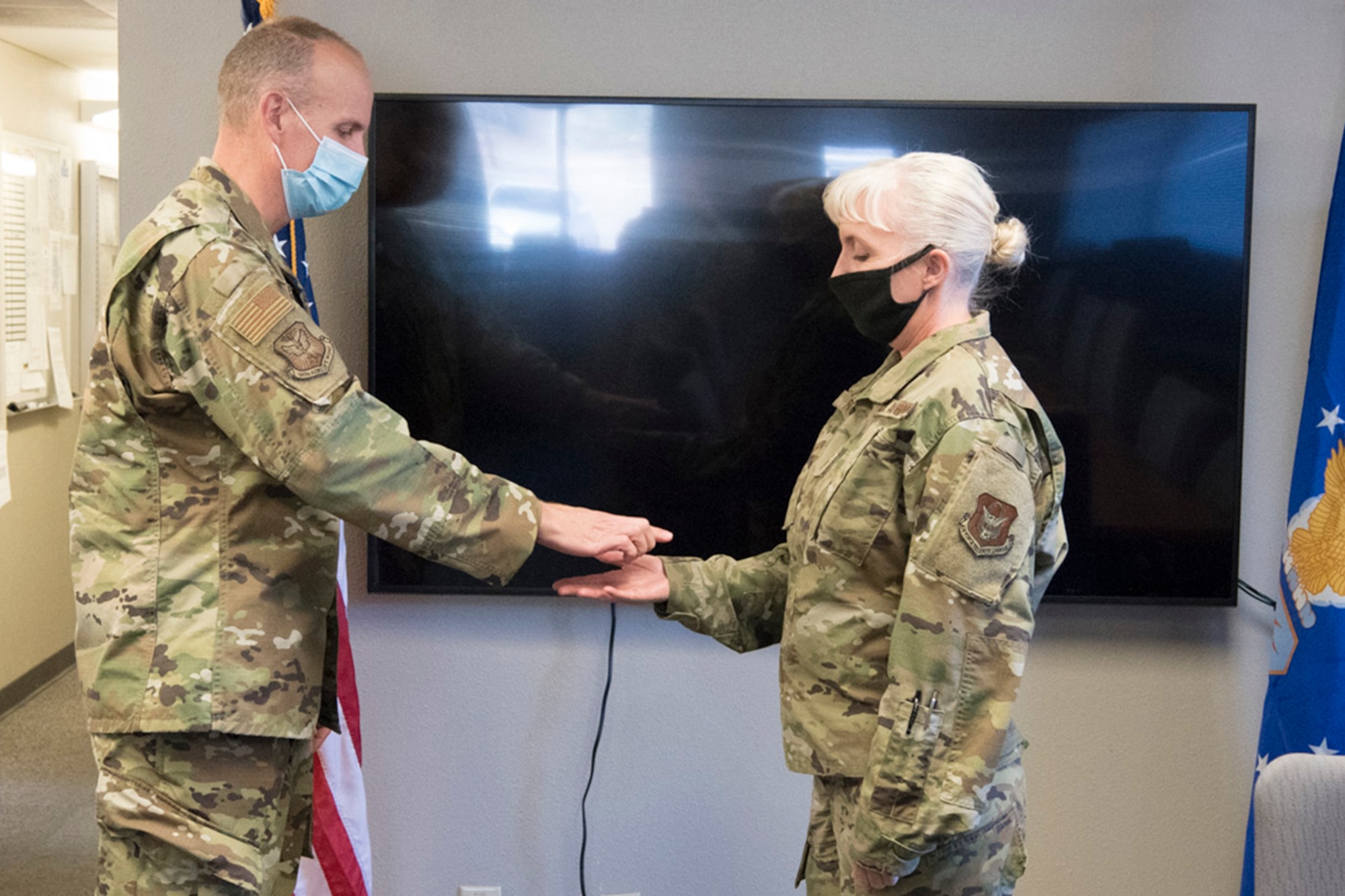 Col. Christopher Zidek, 302nd Airlift Wing commander, coins Master Sgt. Sandy Riley, 302nd Maintenance Squadron Aerospace Ground Equipment flight chief, during the December unit training assembly, Dec. 5, 2020, at Peterson-Schriever Garrison, Colorado.