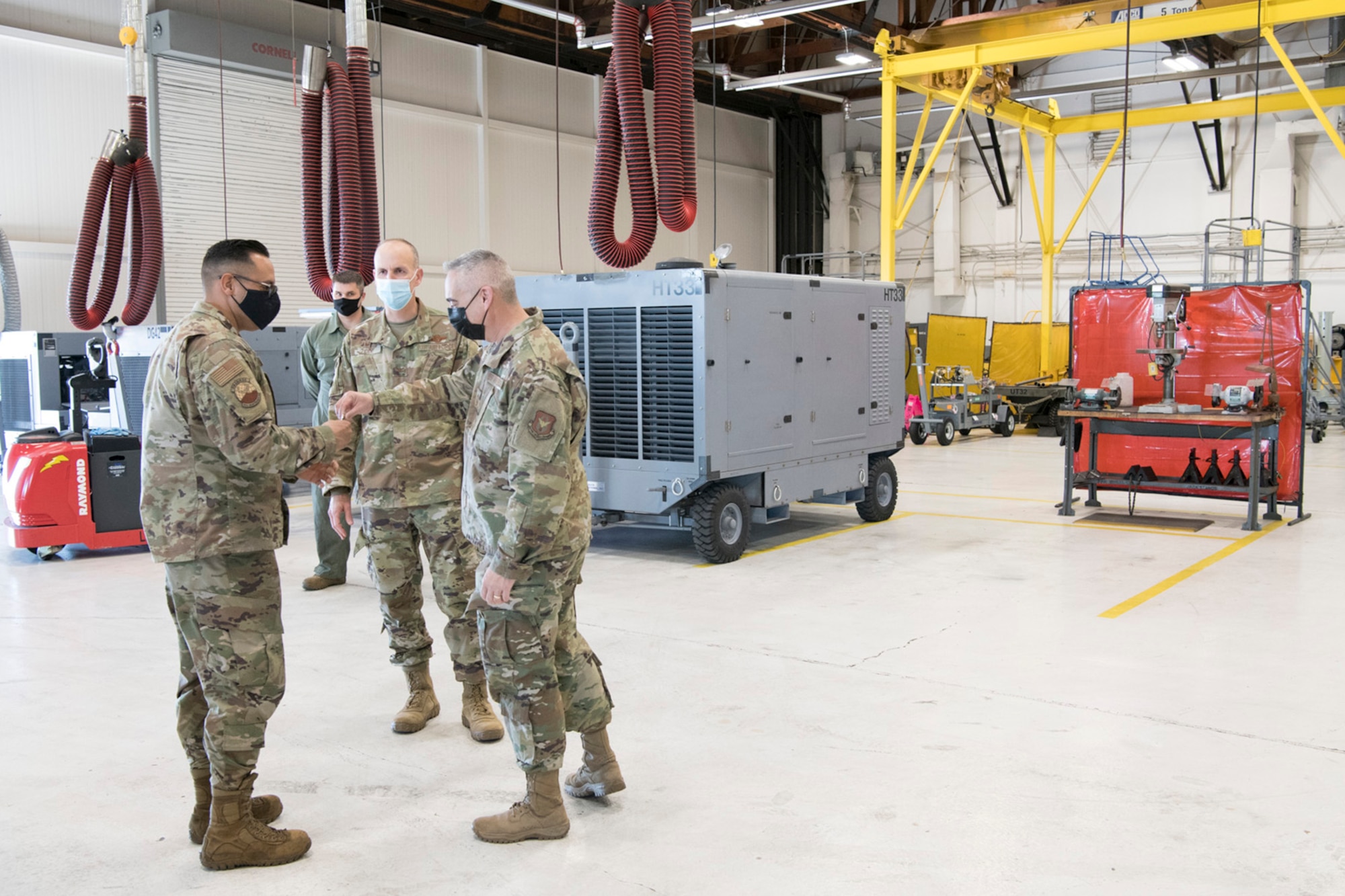 Chief Master Sgt. Kahn Scalise, 302nd Airlift Wing command chief, coins Tech. Sgt. Ivan Vela, 302nd Maintenance Squadron Aerospace Ground Equipment technician, during the December unit training assembly, Dec. 5, 2020, at Peterson-Schriever Garrison, Colorado.