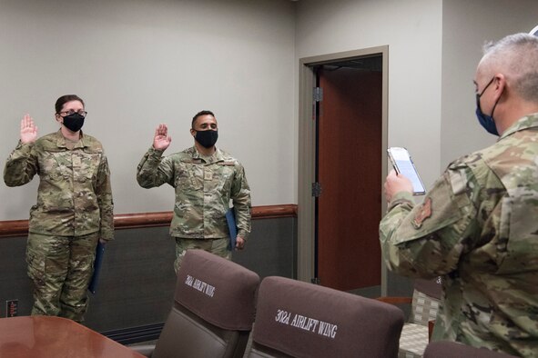 Master Sgts Allison Heckenkamp and Carlos Gonzalez III, 302nd Airlift Wing wing inspection team, recite the Oath of Enlistment after being promoted to the rank of master sergeants during the December unit training assembly, Dec. 5, 2020, at Peterson-Schriever Garrison, Colorado.