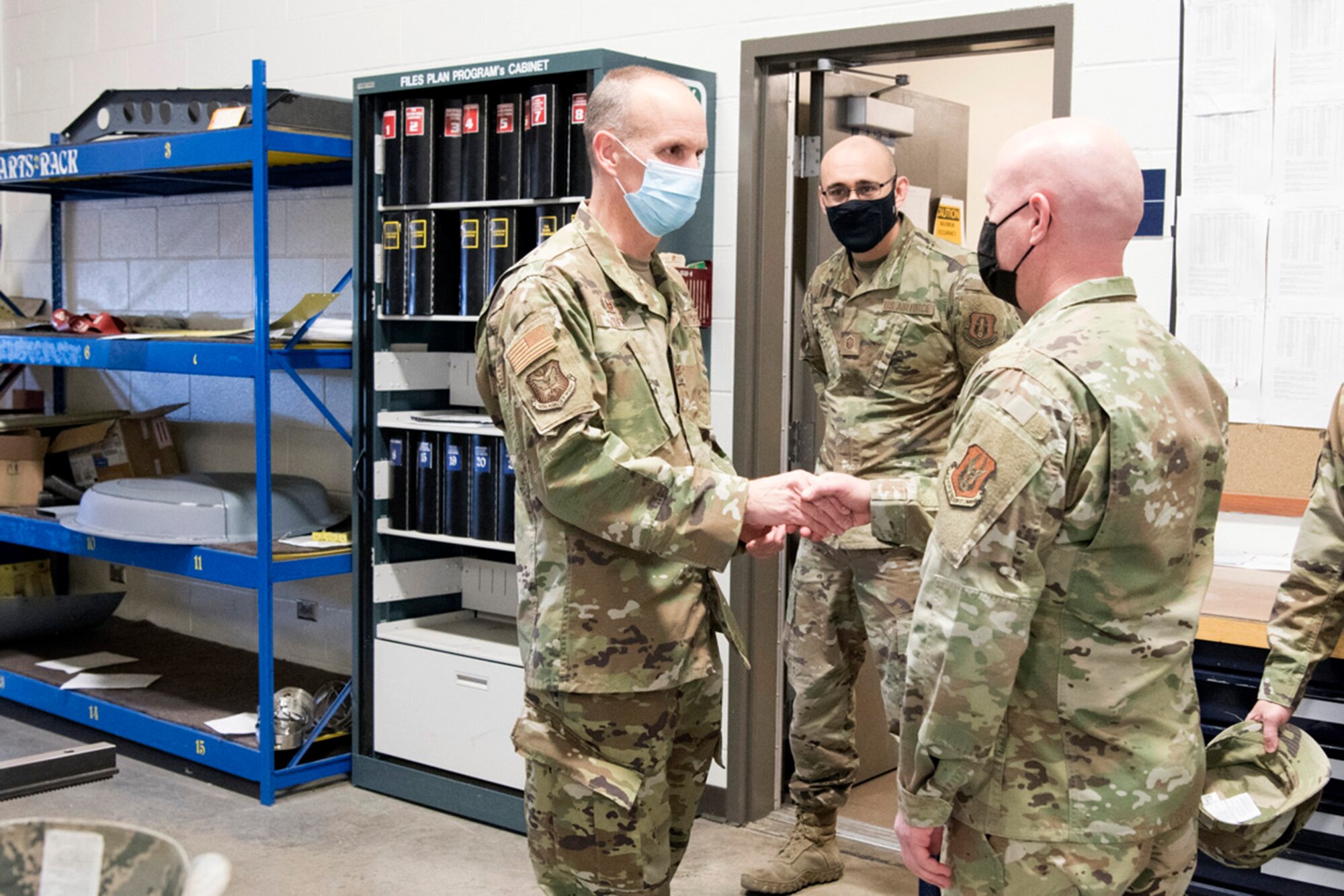 Col. Christopher Zidek, 302nd Airlift Wing commander, coins Senior Master Sgt. William Harris, 302nd Maintenance Squadron Aircraft Fabrication flight chief, during the December unit training assembly, Dec. 5, 2020, at Peterson-Schriever Garrison, Colorado.