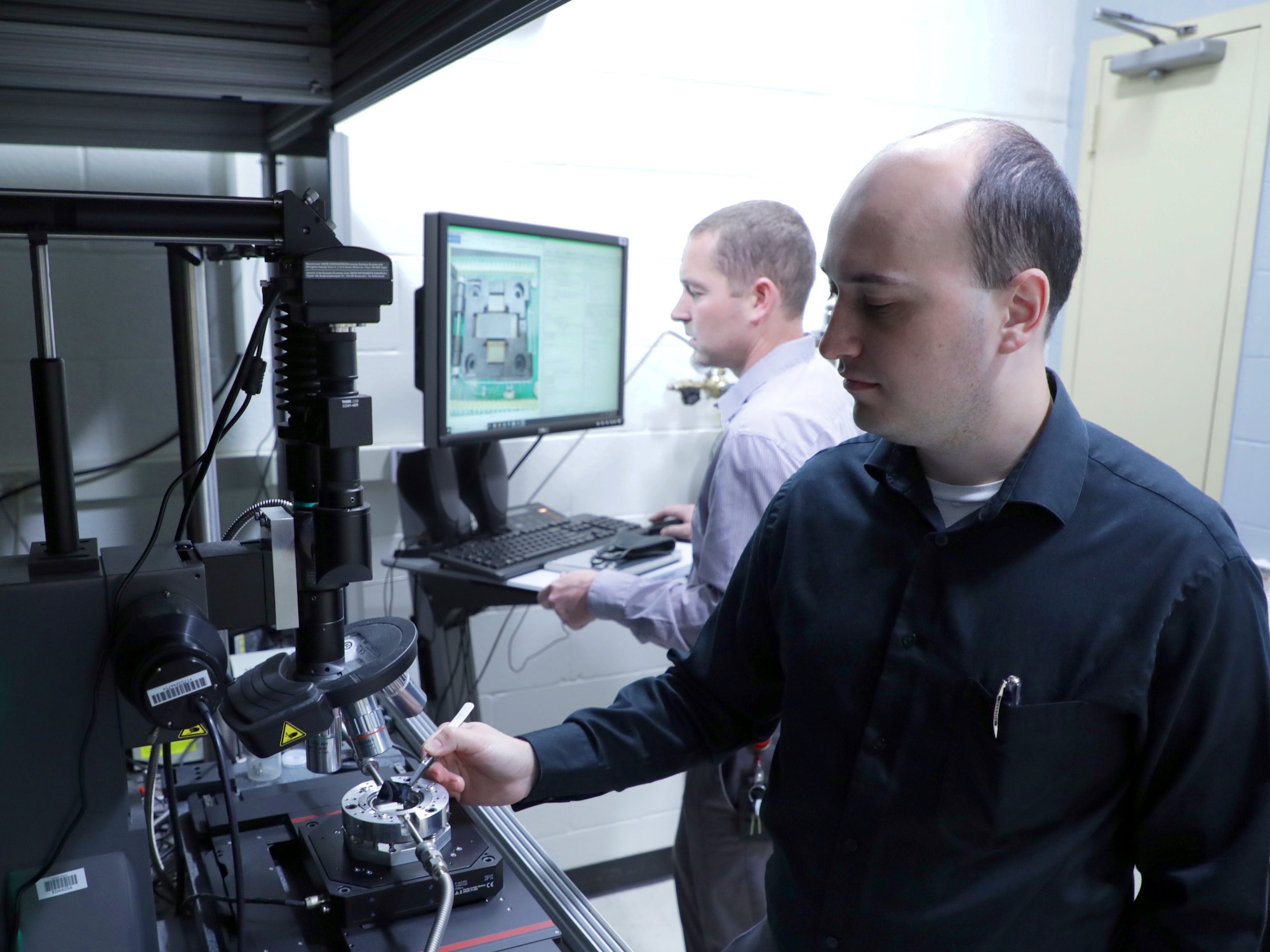 Researchers Dr. Drake Austin (UES, Inc.) and Dr. Nicholas Glavin (Air Force Research Laboratory) in the laser writing of electronics laboratory. (U.S. Air Force photo/Spencer Deer)