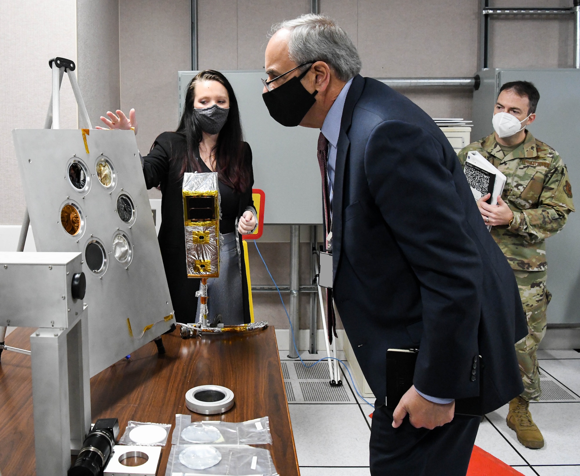 Dr. Richard Joseph, center, Air Force chief scientist, looks at material samples that underwent recent testing, as Kellye Burns, left, an Arnold Engineering Development Complex space test engineer briefs him during his visit to Arnold Air Force Base, Tenn., Nov. 18, 2020. Also pictured is Col. Mario Serna, military assistant to the Air Force chief scientist. Test and evaluation of space materials is conducted to understand their performance in and susceptibility to a realistic space environment. (U.S. Air Force photo by Jill Pickett) (This image was altered by obscuring a badge for security purposes.)