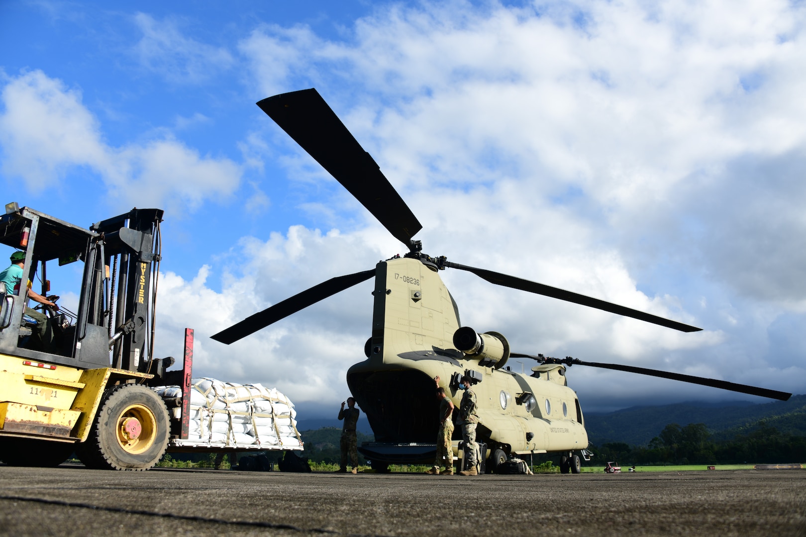 U.S. Army CH-47 Chinook crew members assigned to the 1st Battalion, 228th Aviation Regiment, Joint Task Force-Bravo guide a forklift operator to a CH-47 Chinook at La Ceiba, Honduras, Nov. 30, 2020. The humanitarian aid food items will be delivered in the vicinity of Puerto Lempira to assist those isolated by the effects of Hurricane Iota.