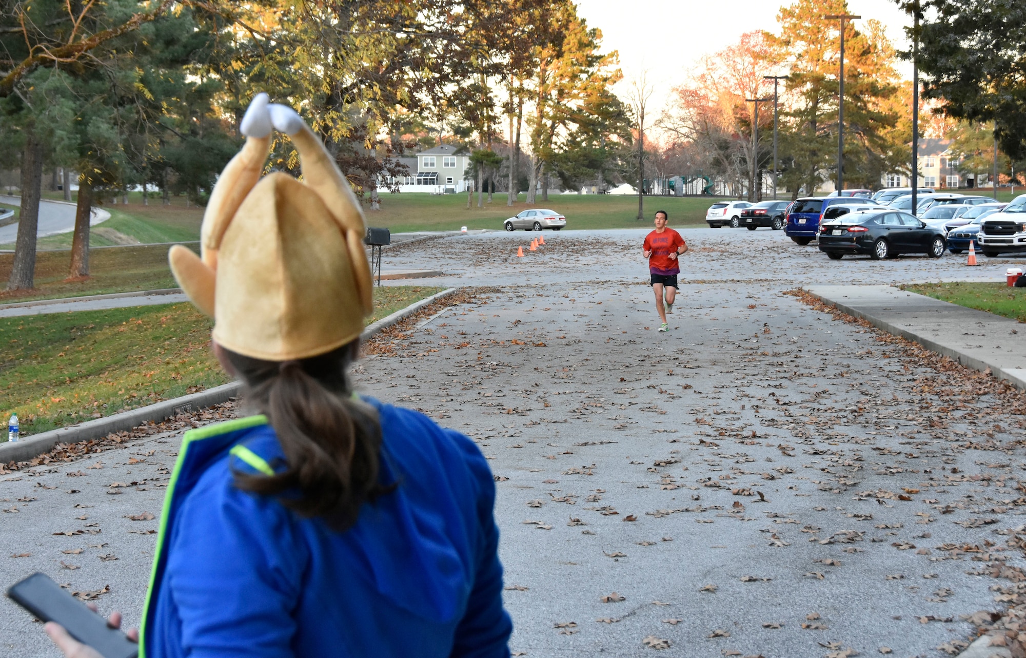 AEDC Commander Col. Jeffrey Geraghty nears the finish line as Capt. Elizabeth Sewell prepares to record his time during the 35th annual AEDC Turkey Trot, Nov. 13, 2020, at the Arnold Lakeside Complex on Arnold Air Force Base, Tenn. (U.S. Air Force photo by Bradley Hicks)